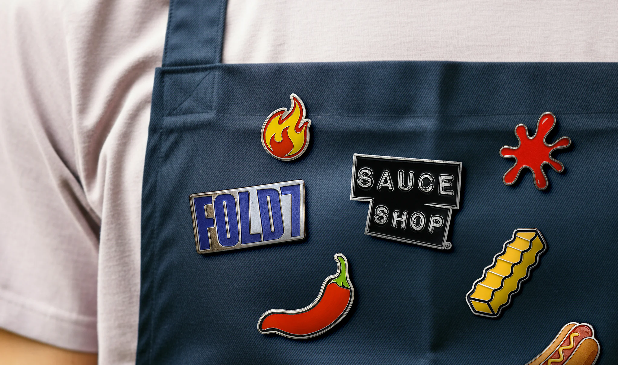 Image of an apron with sauce shop & fold7 logo badges