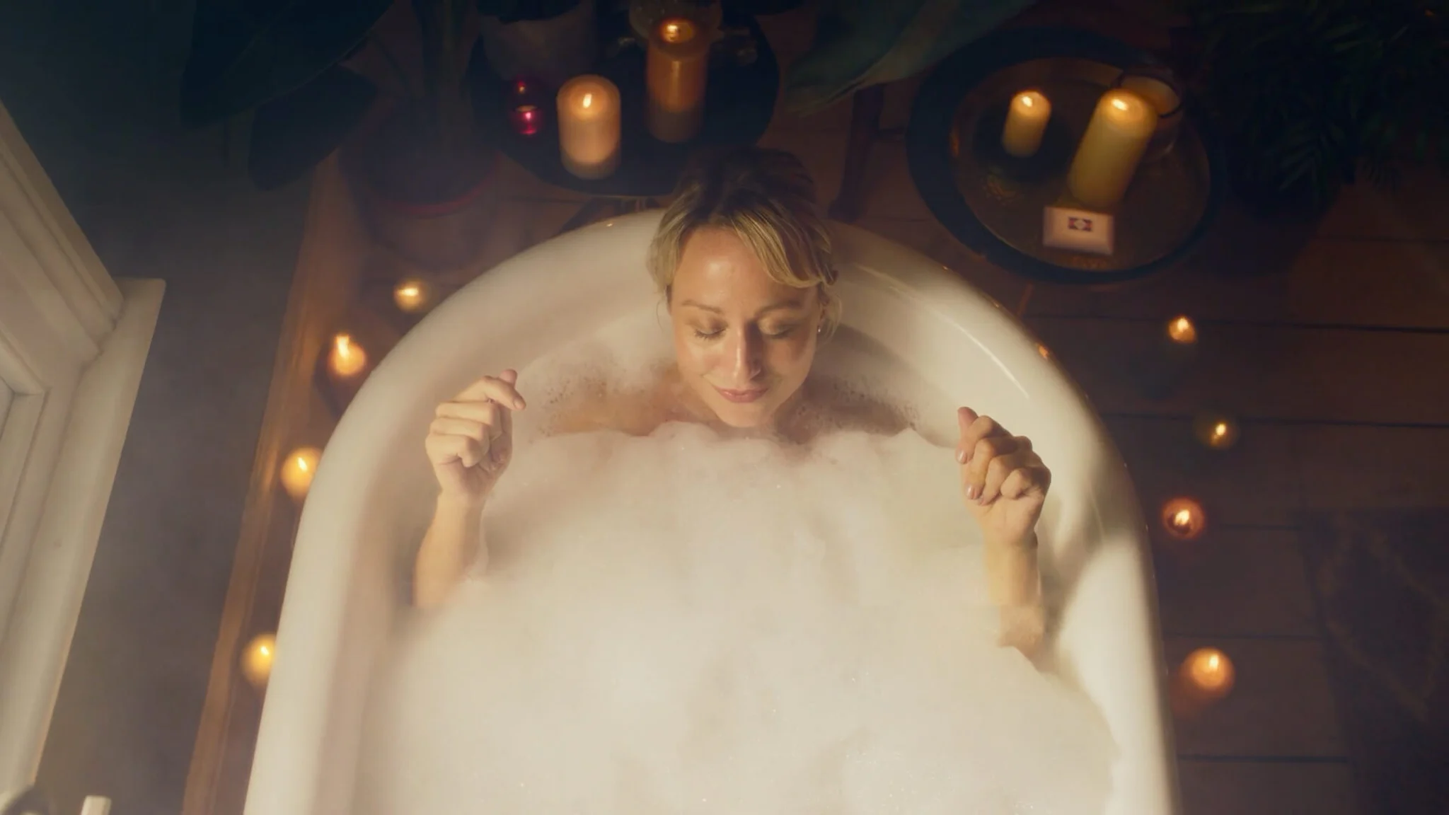 Woman in a bath with candles enjoying PZC Imperial Leather