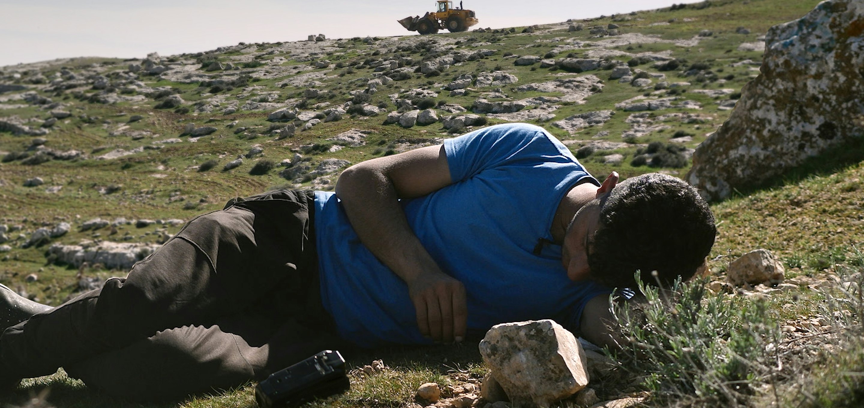 No Other Land - man lying on grass