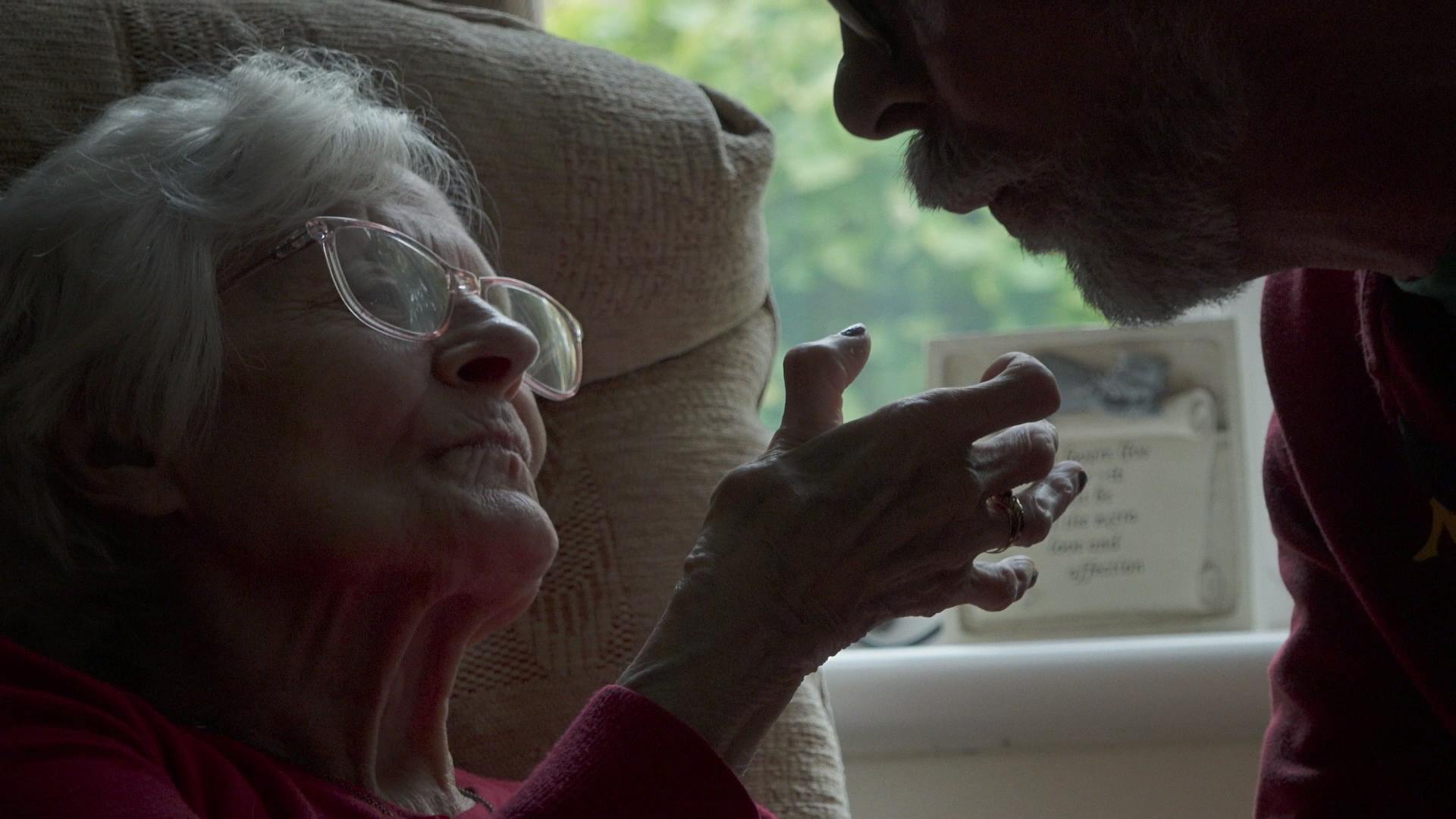 an older woman holds out her hand to her son
