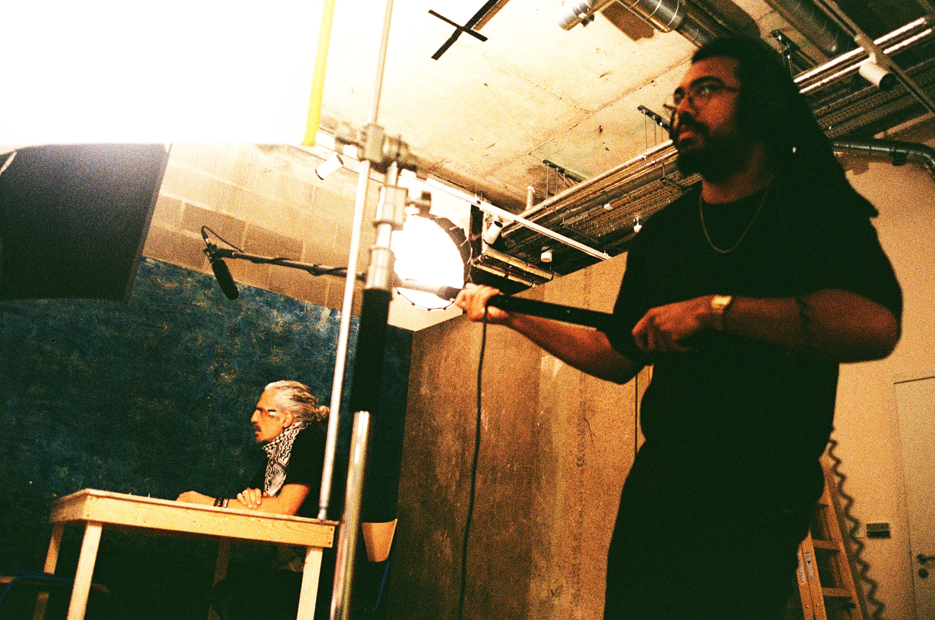 a man with a camera and a man at a table editing