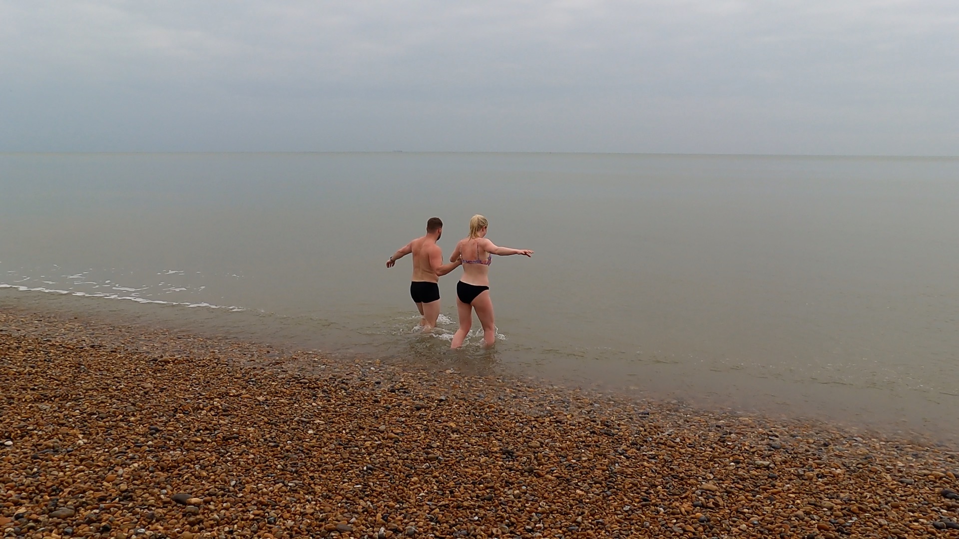 two people going into the sea at Sandgate beach