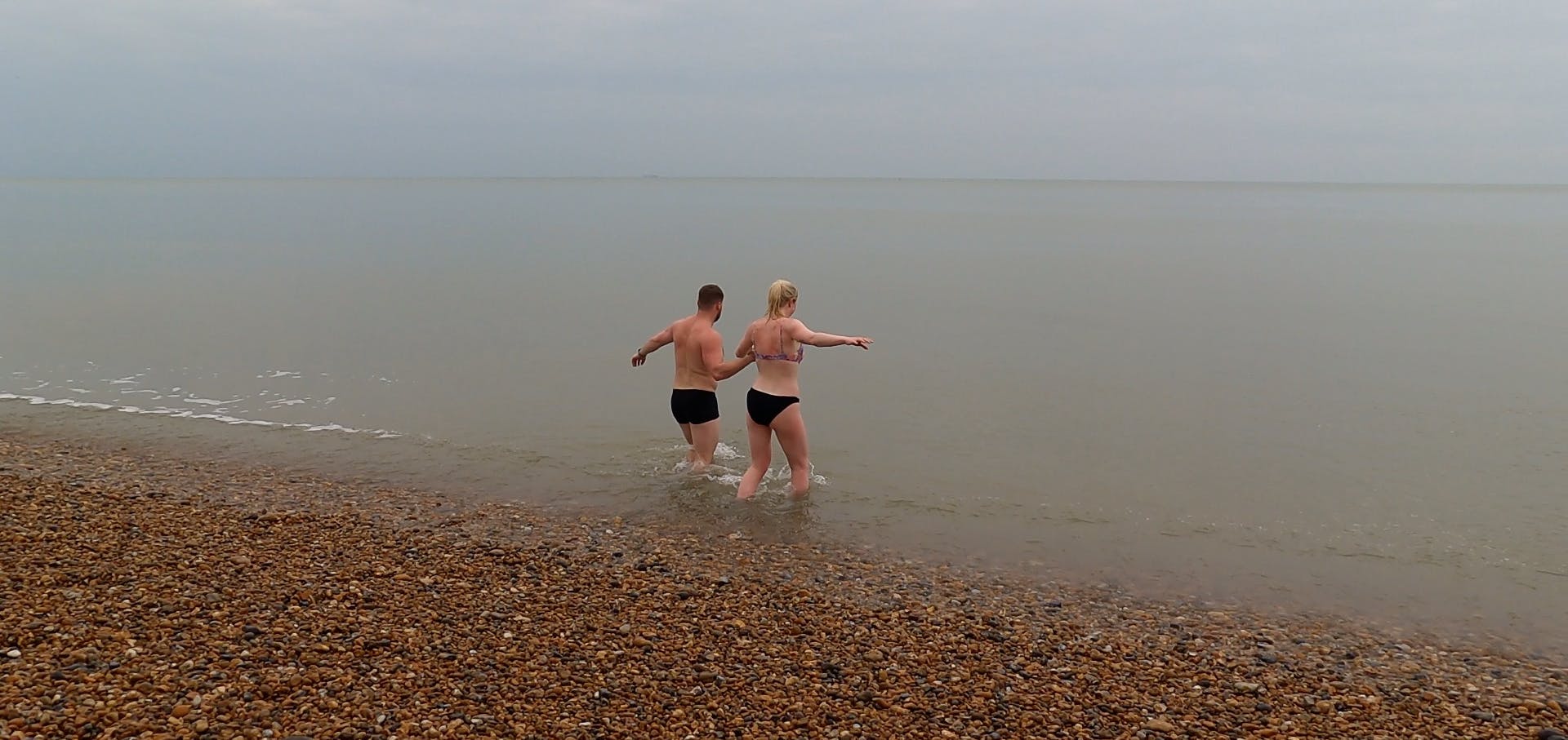 two people going into the sea at Sandgate beach