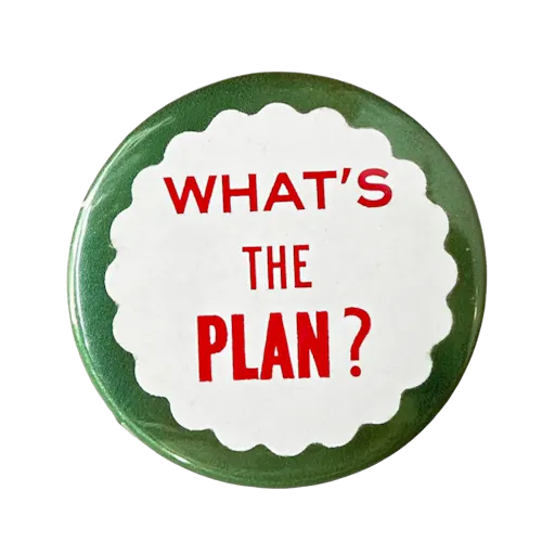 Badge rond vert et blanc avec l’inscription rouge « What’s the Plan? » au centre.