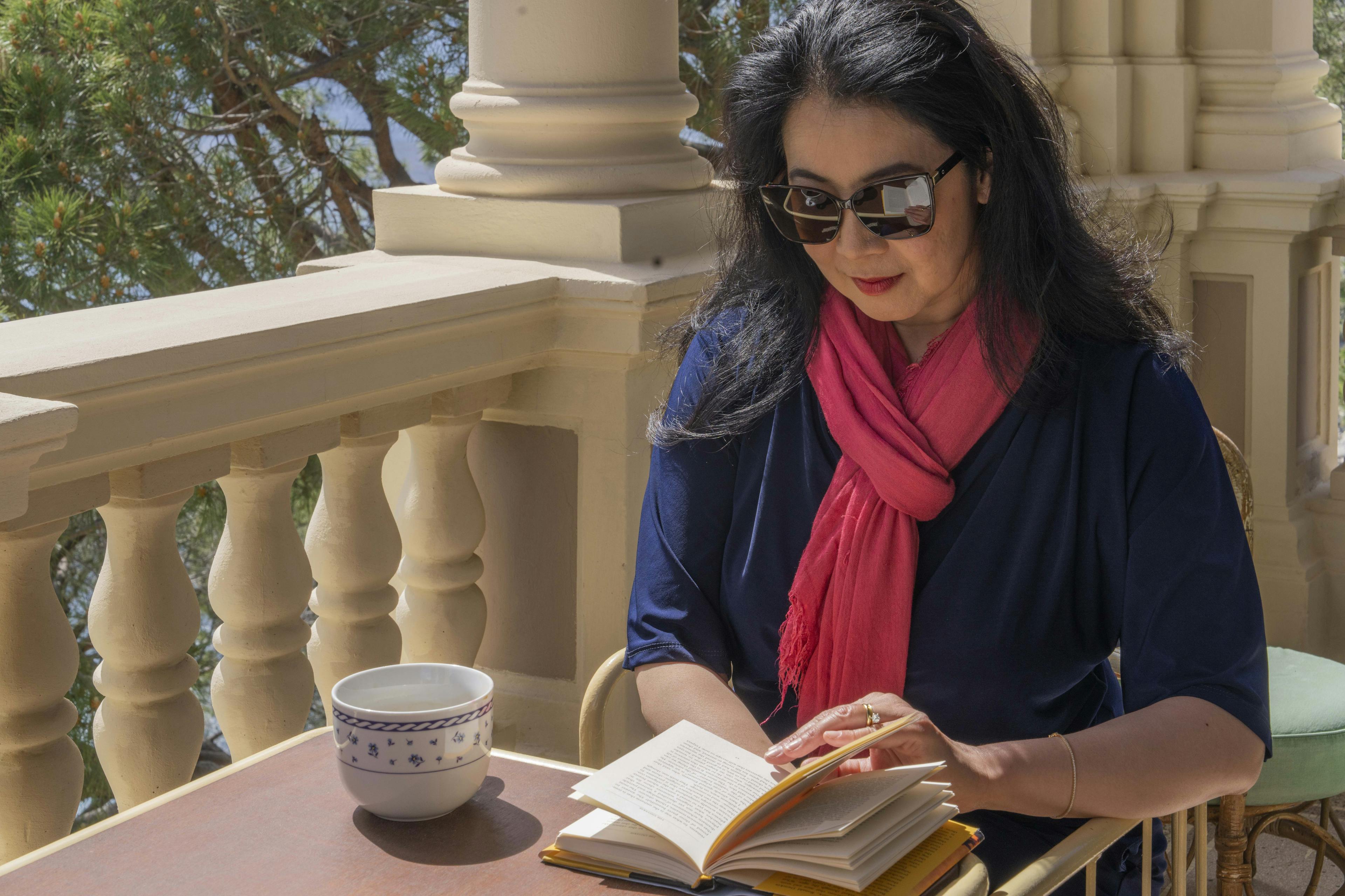 Ragazza legge un libro seduta con una tazza di caffè