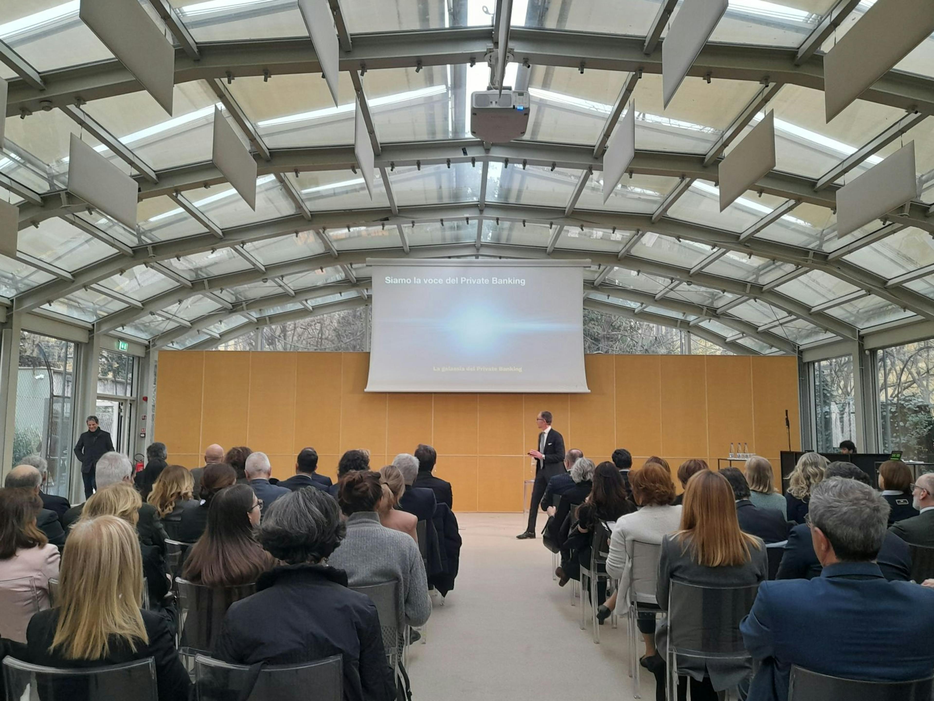 Sala con pubblico che guarda la presentazione proiettata all'evento "Private banking e Filantropia" di FFI e AIPB