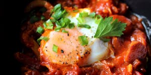 Close up of an egg in a pan of shakshouka