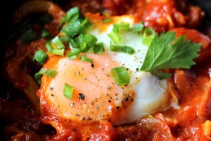 Close up of an egg in a pan of shakshouka