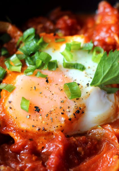 Close up of an egg in a pan of shakshouka