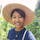 Photo of Han Jing outdoors with a farm hat.