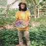 Marcus Koe in his garden with a basket of edible flower and okra