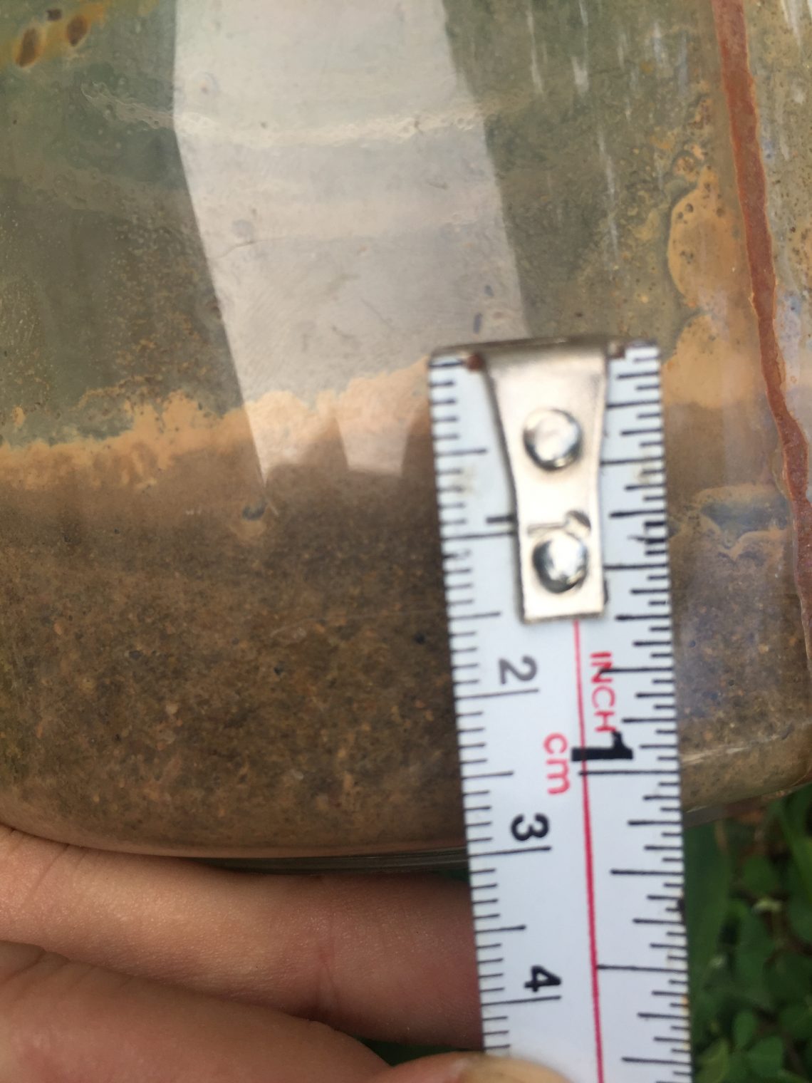 Soil texture being sampled in mason jar