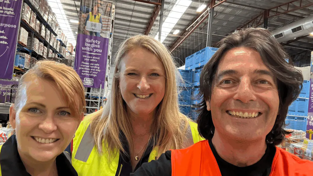 The Food Relief Triangle, part two Three people in high-visibility vests inside Foodbank's Perth warehouse