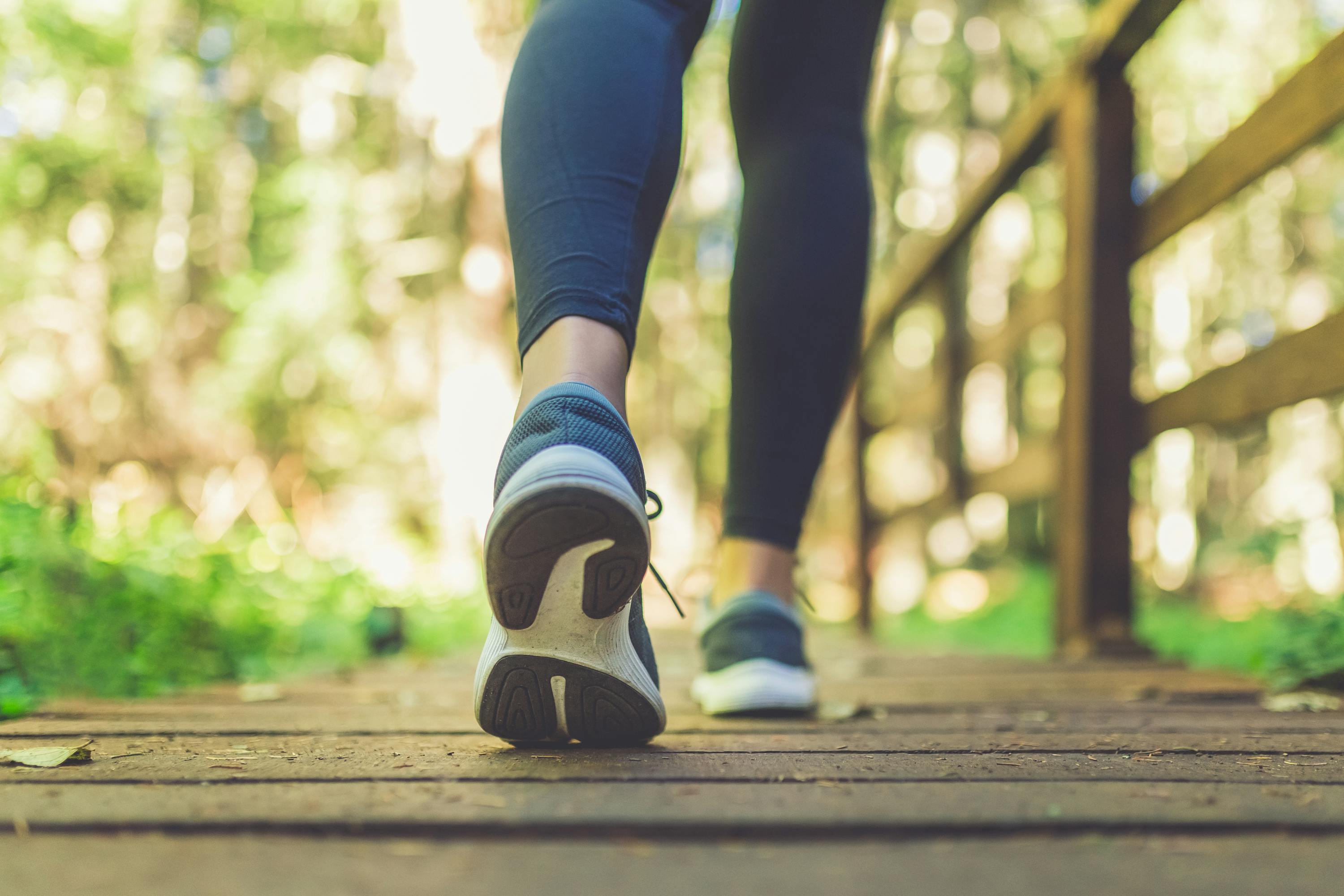 Feet walking on a wooden bridge in the woods