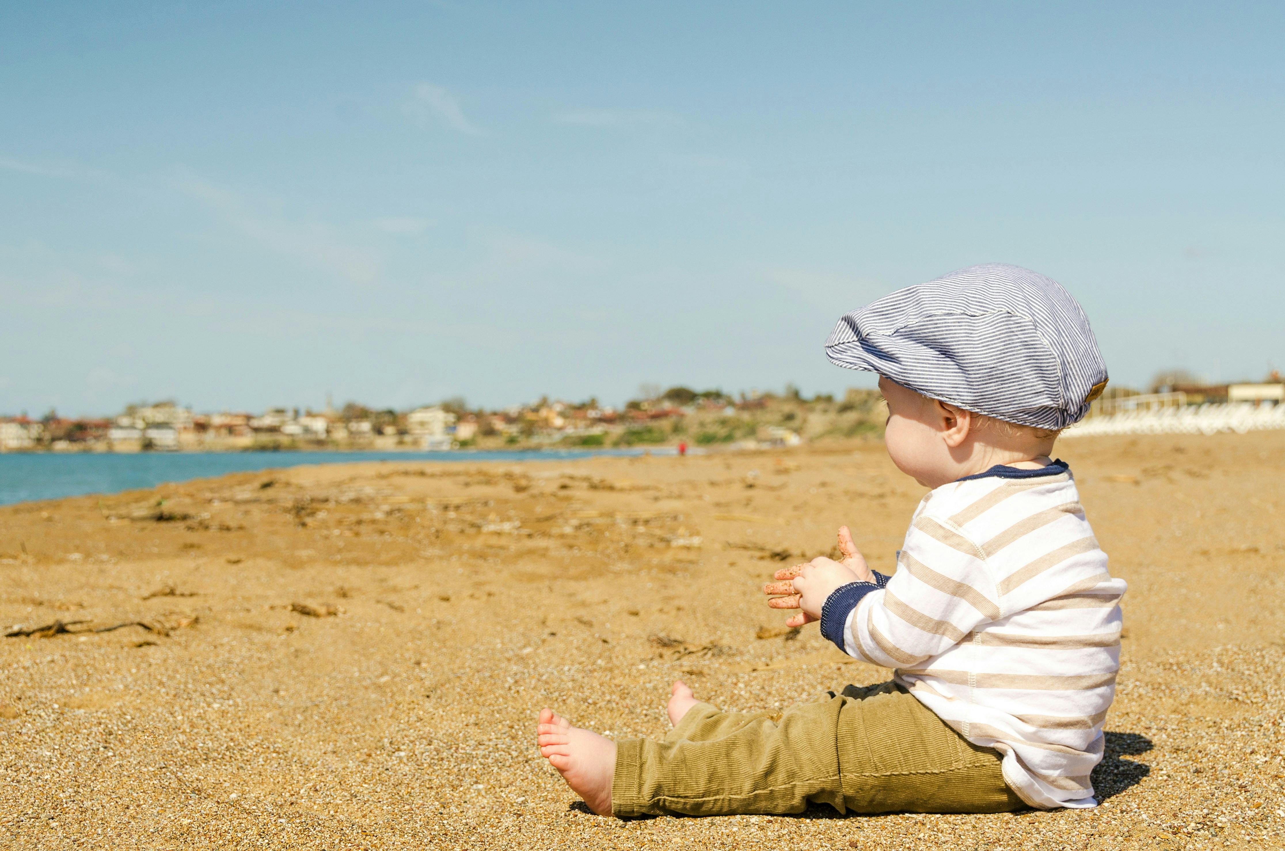 Barn sitter på beachen föräldraledig 