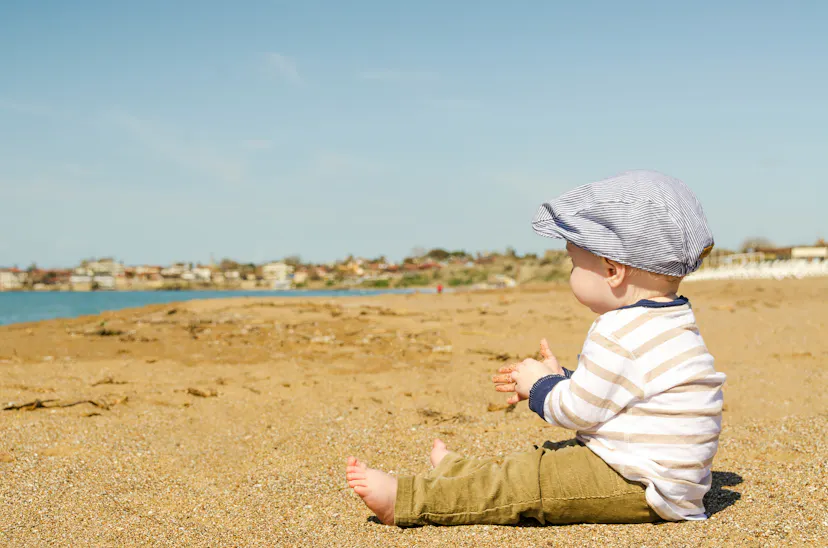 Barn sitter på beachen föräldraledig