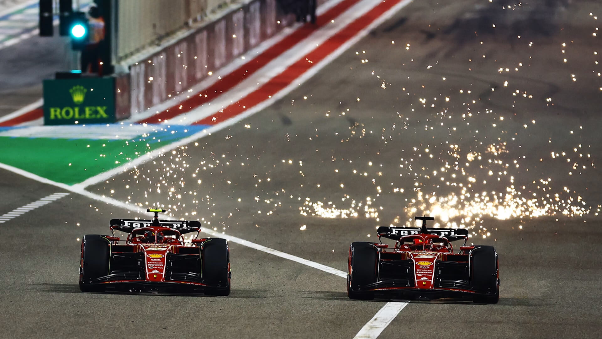 Sparks erupts as two Ferrari engage in a thrilling wheel-to-wheel battle under the Bahrain night sky.