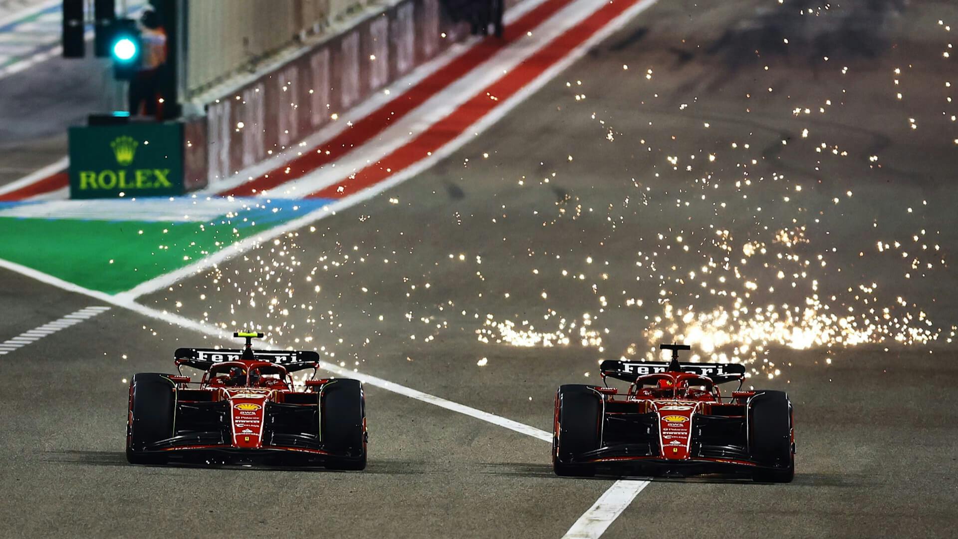 Sparks erupts as two Ferrari engage in a thrilling wheel-to-wheel battle under the Bahrain night sky.