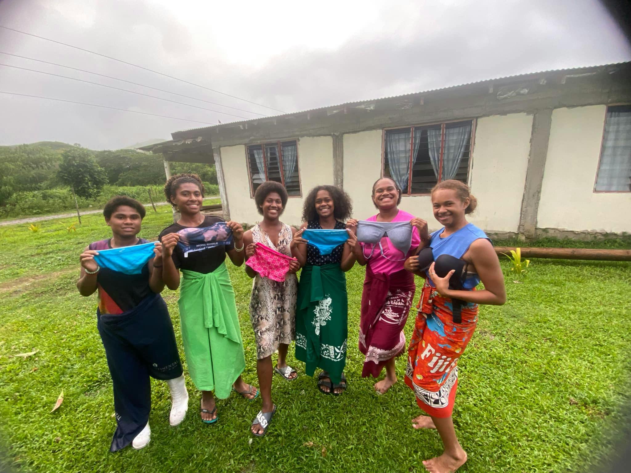 A picture of women in Fiji holding the bras that were donated through Katrina's project