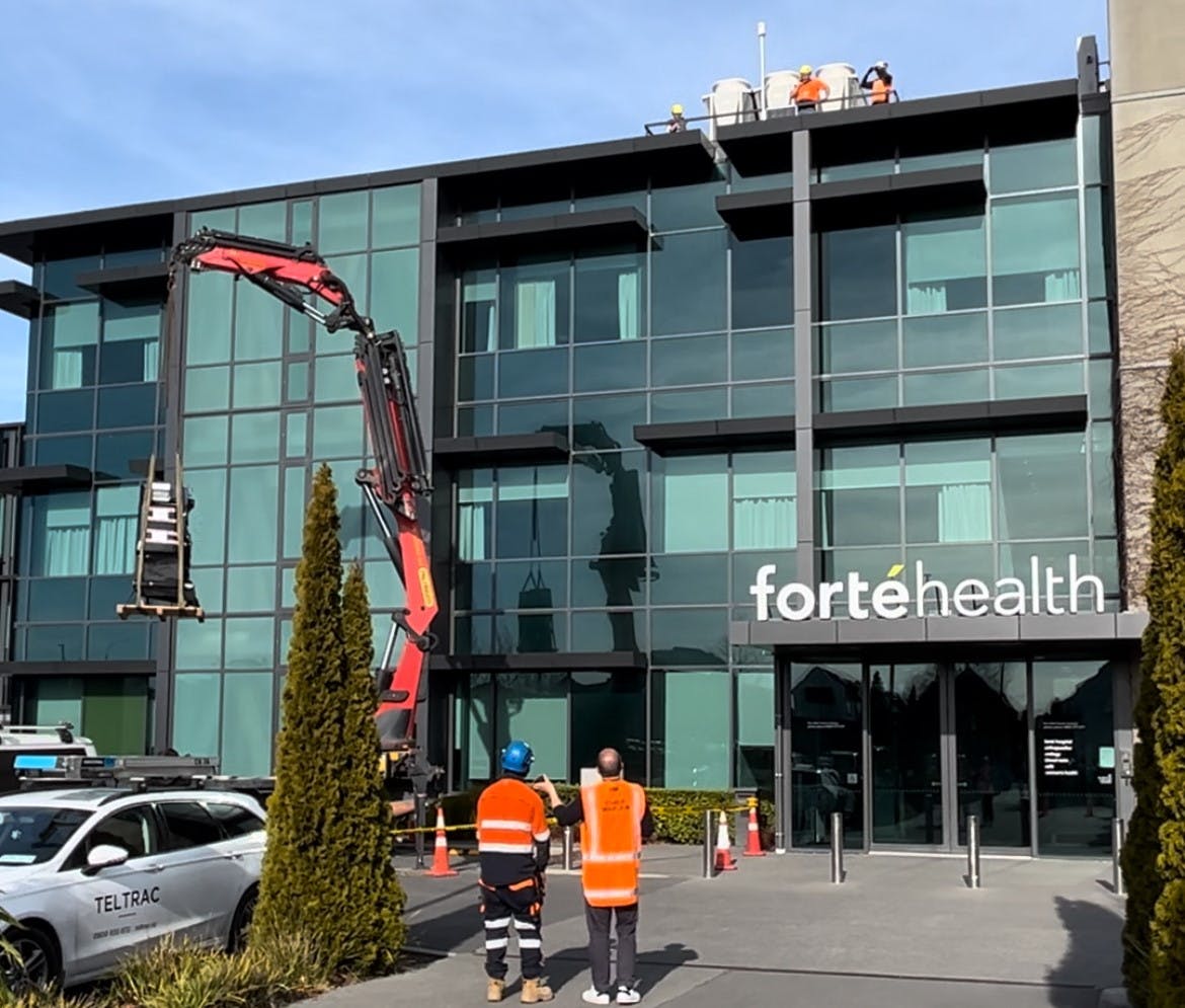 A picture of the new water plant being lifted onto the roof at Forté Health