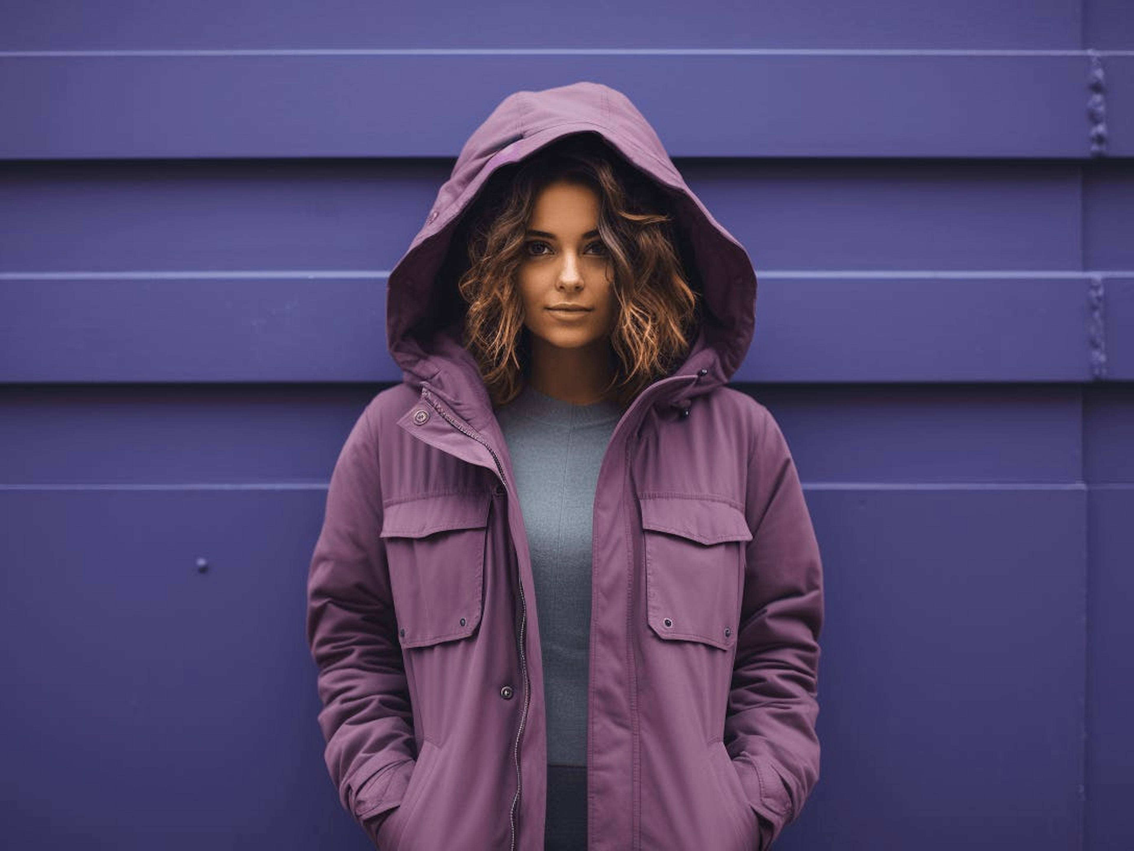 A person wearing a purple jacket from a Colombian brand in the rain