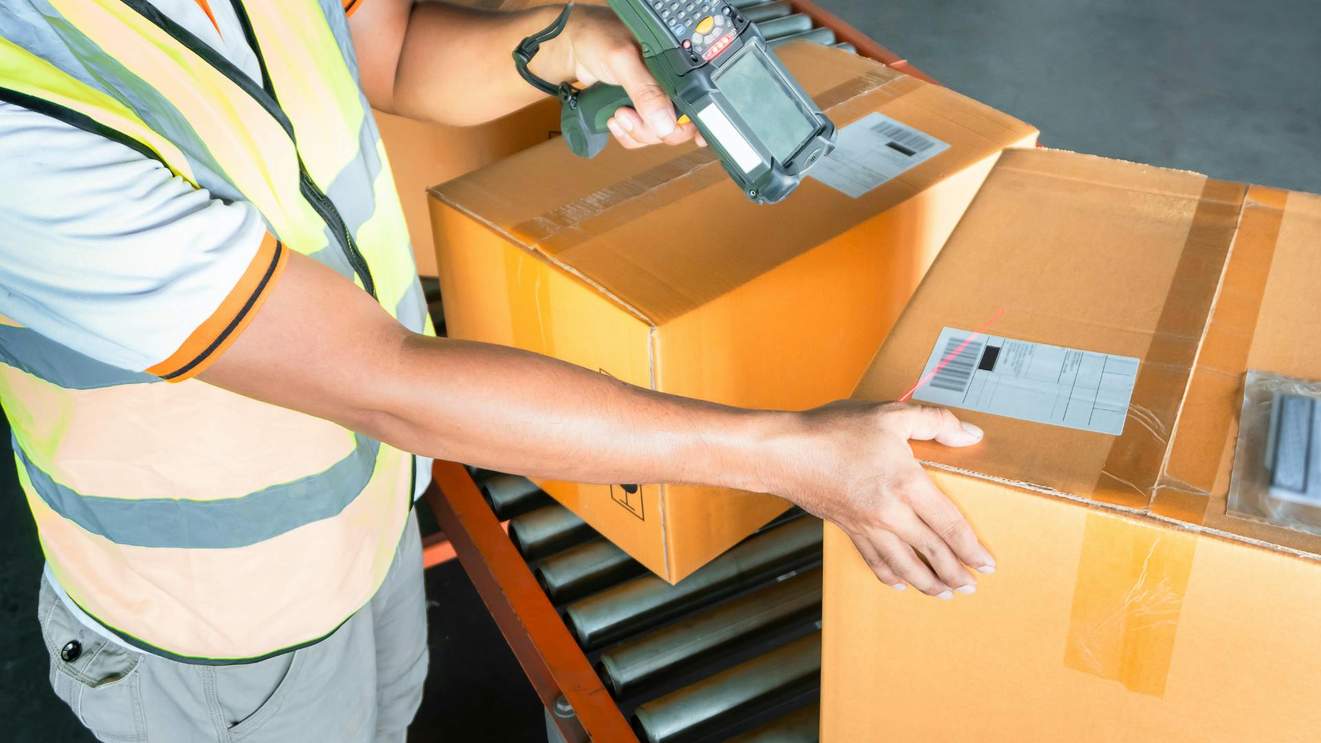 A warehouse worker scanning barcodes of packages to hand them over to the courier company. 
