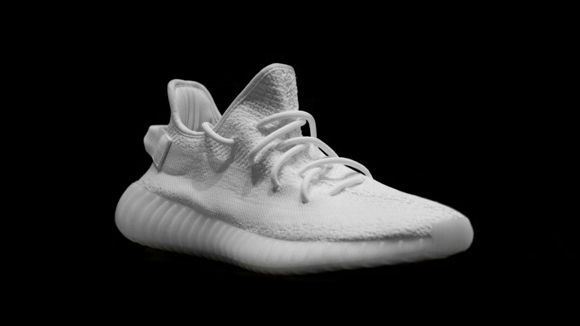 A pair of Kanye West shoe on a black background.