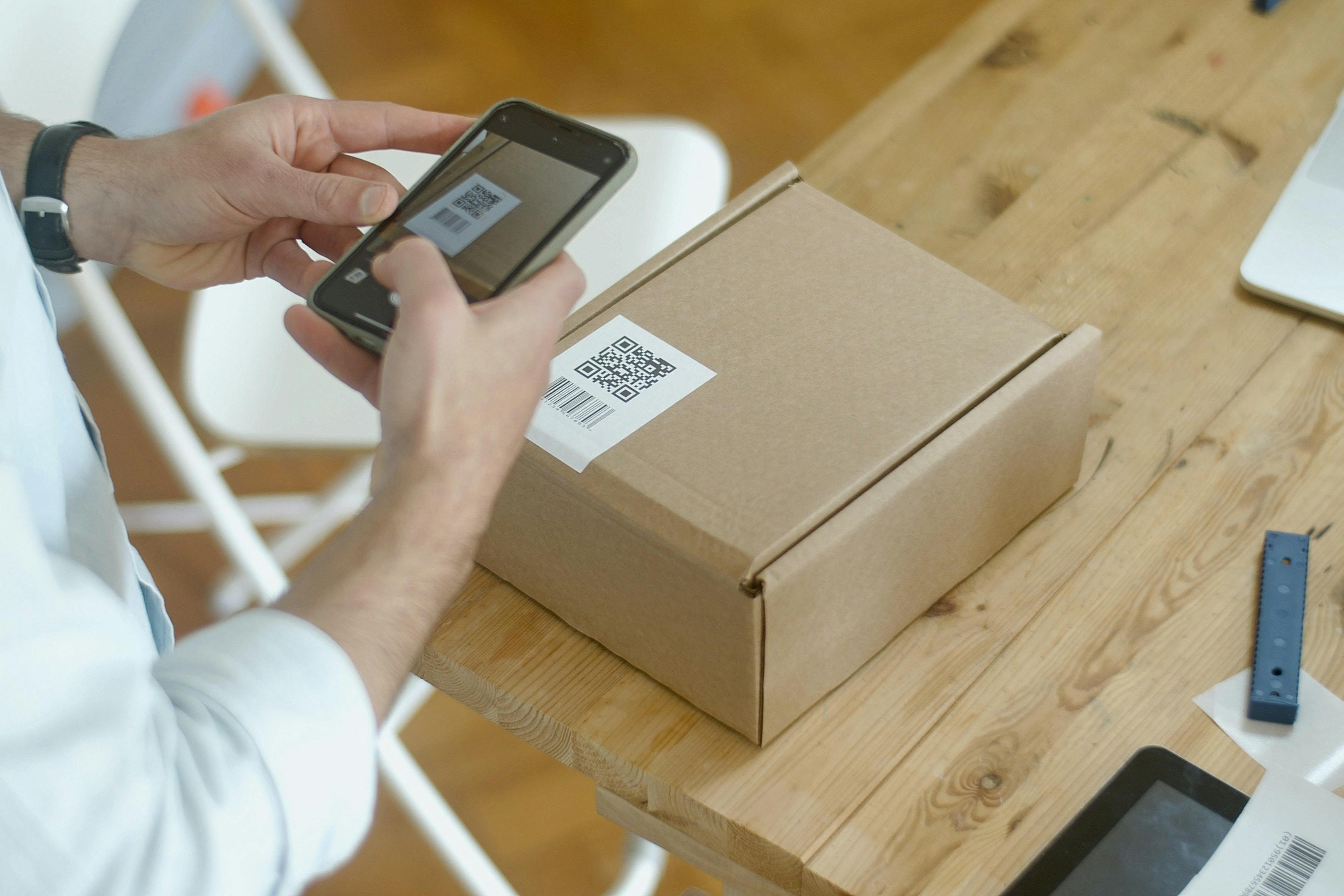 He is monitoring the package using his mobile phone. He is monitoring the package using his mobile phone.