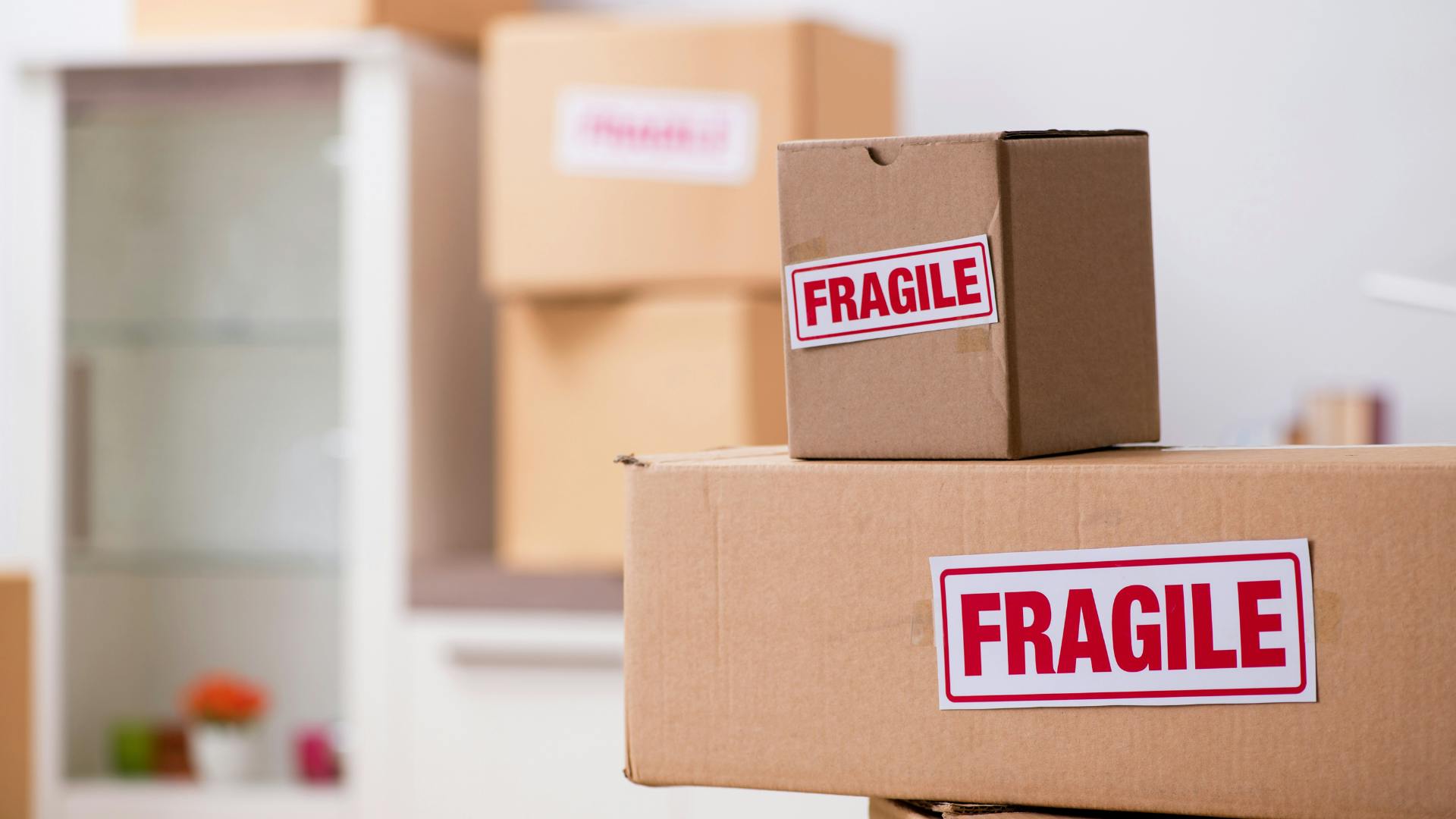 Two package stacked on top of each in the front with Fragile sticker on them. Two more package on the background that stacked on top of each other. Two package stacked on top of each in the front with Fragile sticker on them. Two more package on the background that stacked on top of each other.