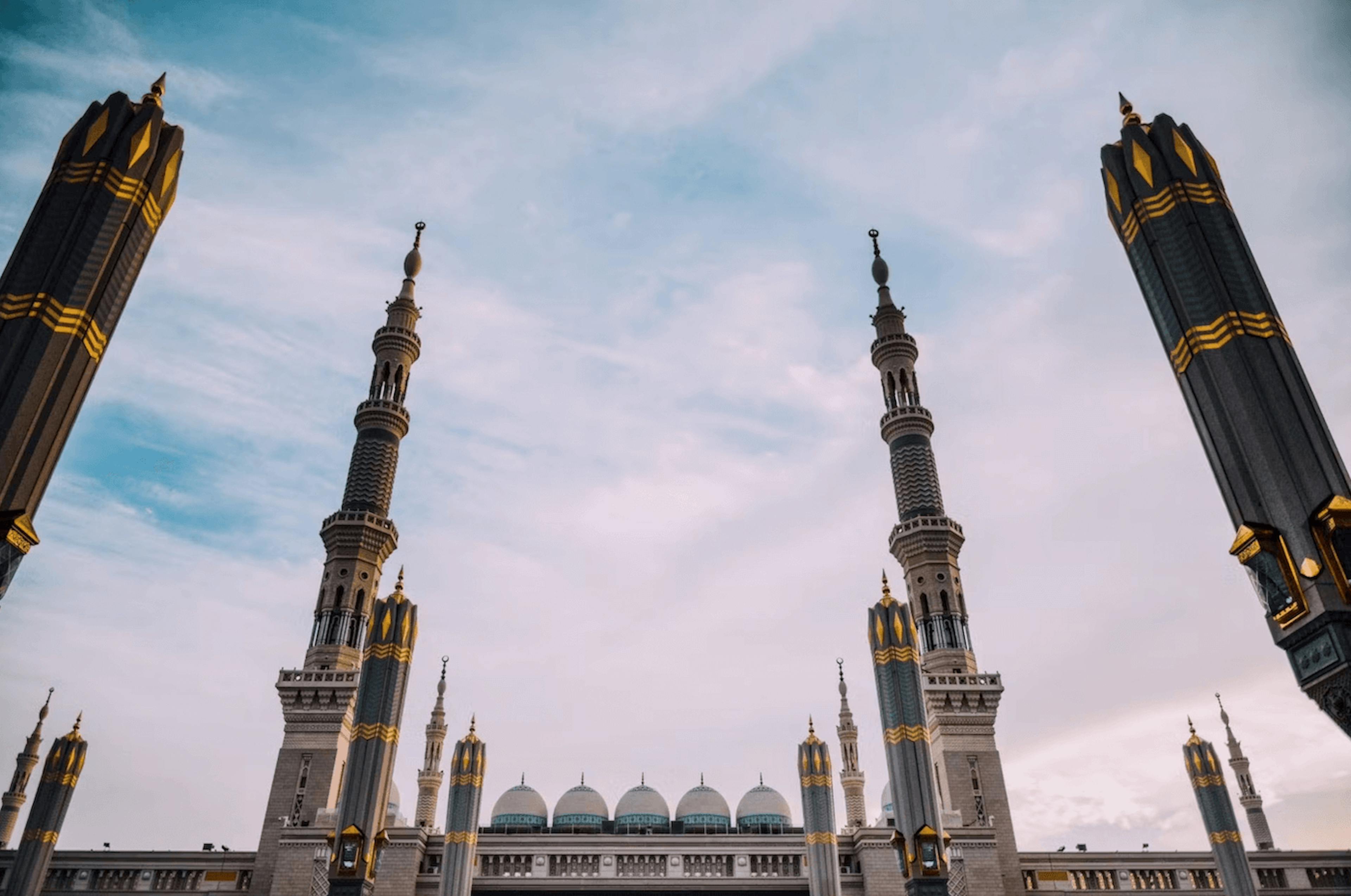 the inside of an elegant mosque with large columns looking out into the sky