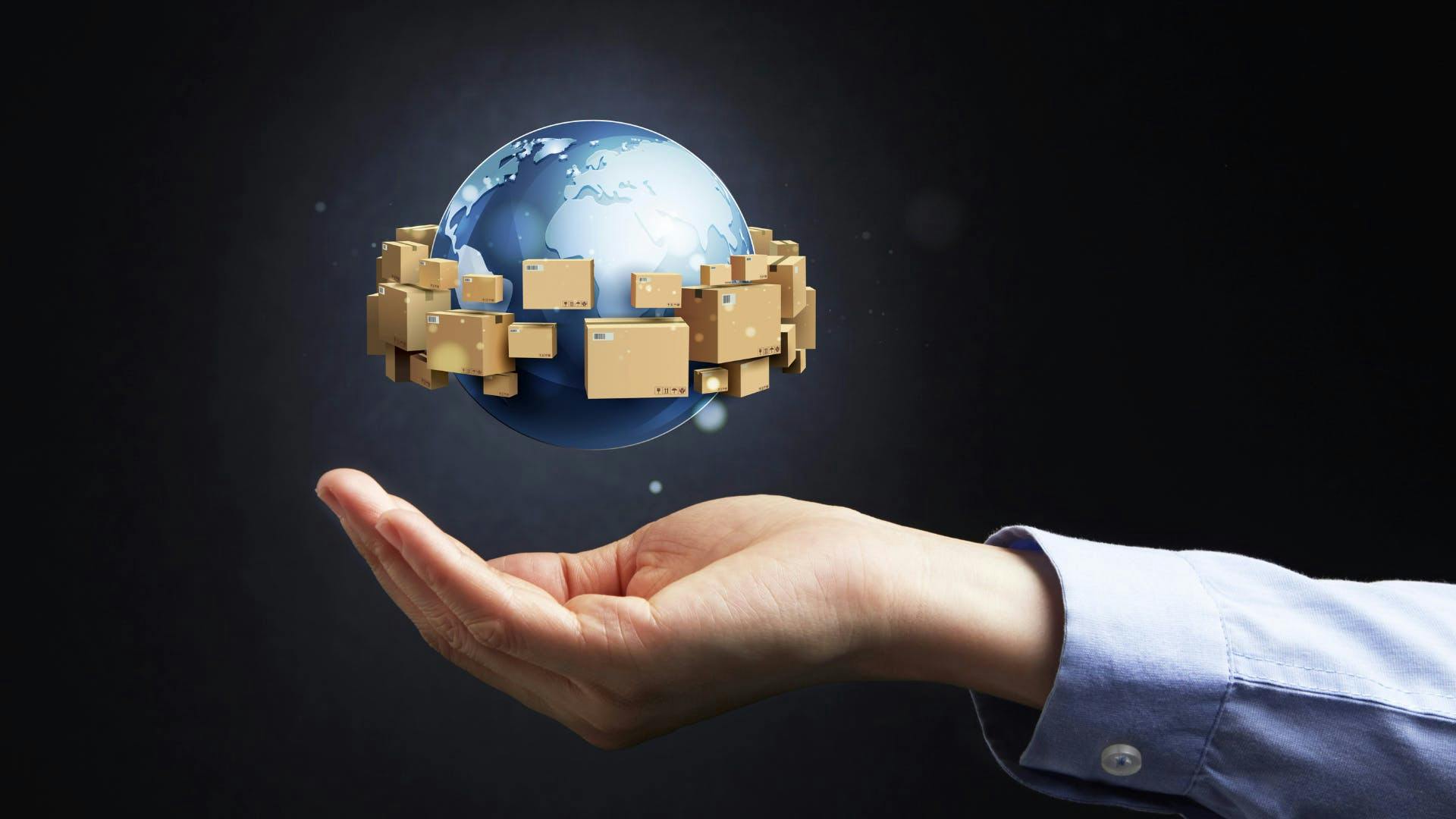 World hovers a mans hand with shipping packages around it. World hovers a mans hand with shipping packages around it.