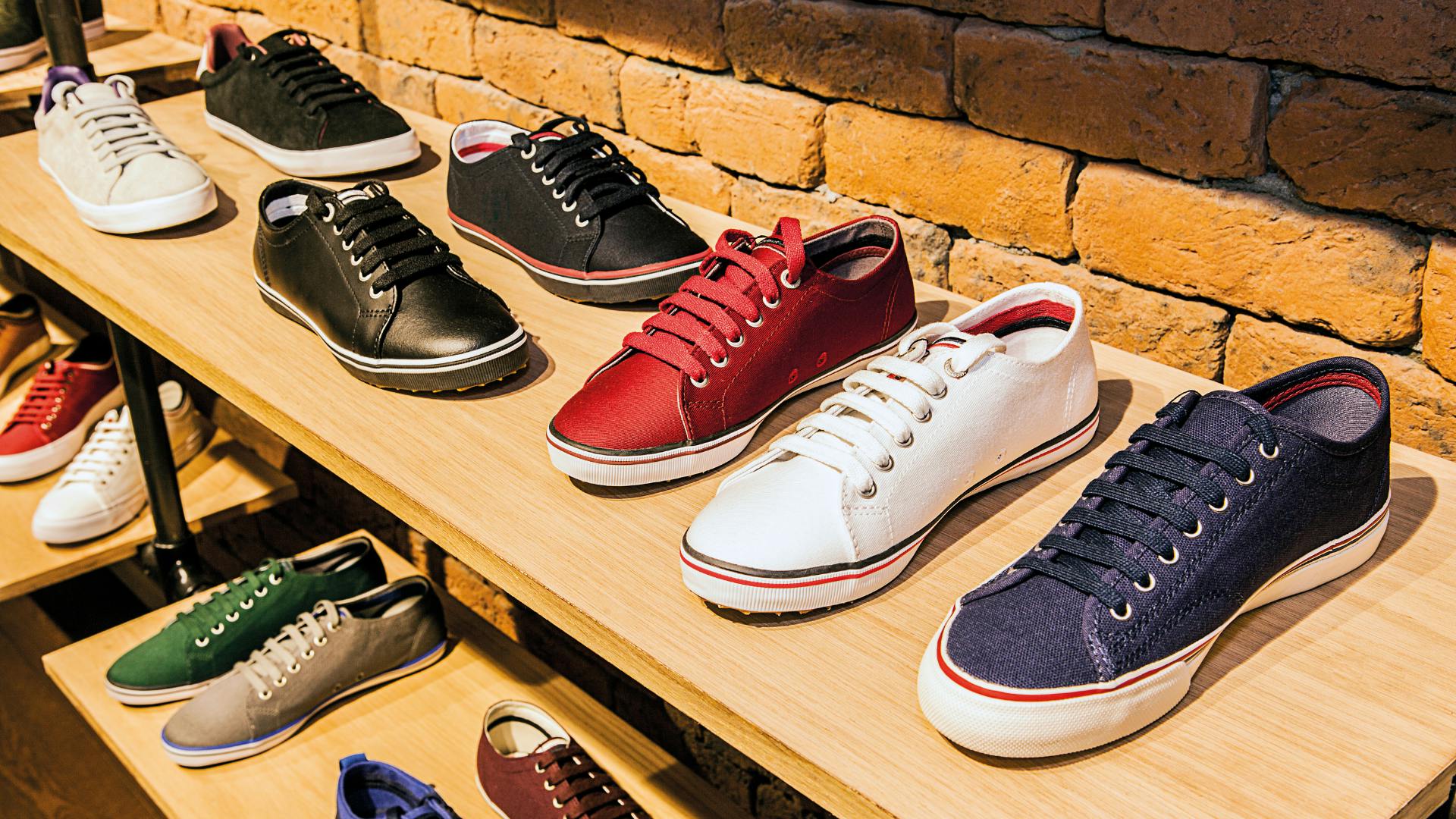 Sneakers lined over shoe rack for selling.