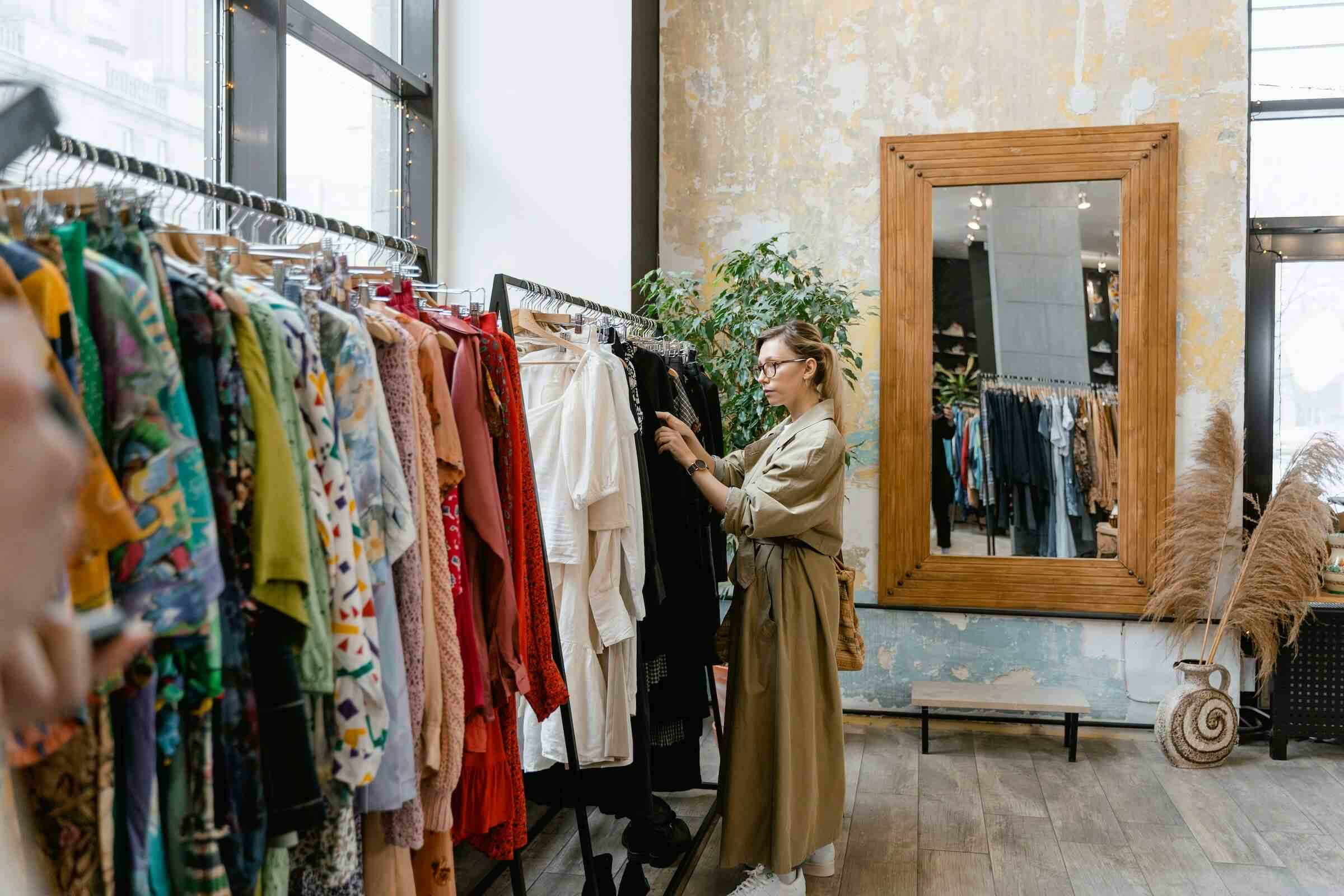 woman shopping fashion from the rack of clothing in a vintage retail center woman shopping fashion from the rack of clothing in a vintage retail center