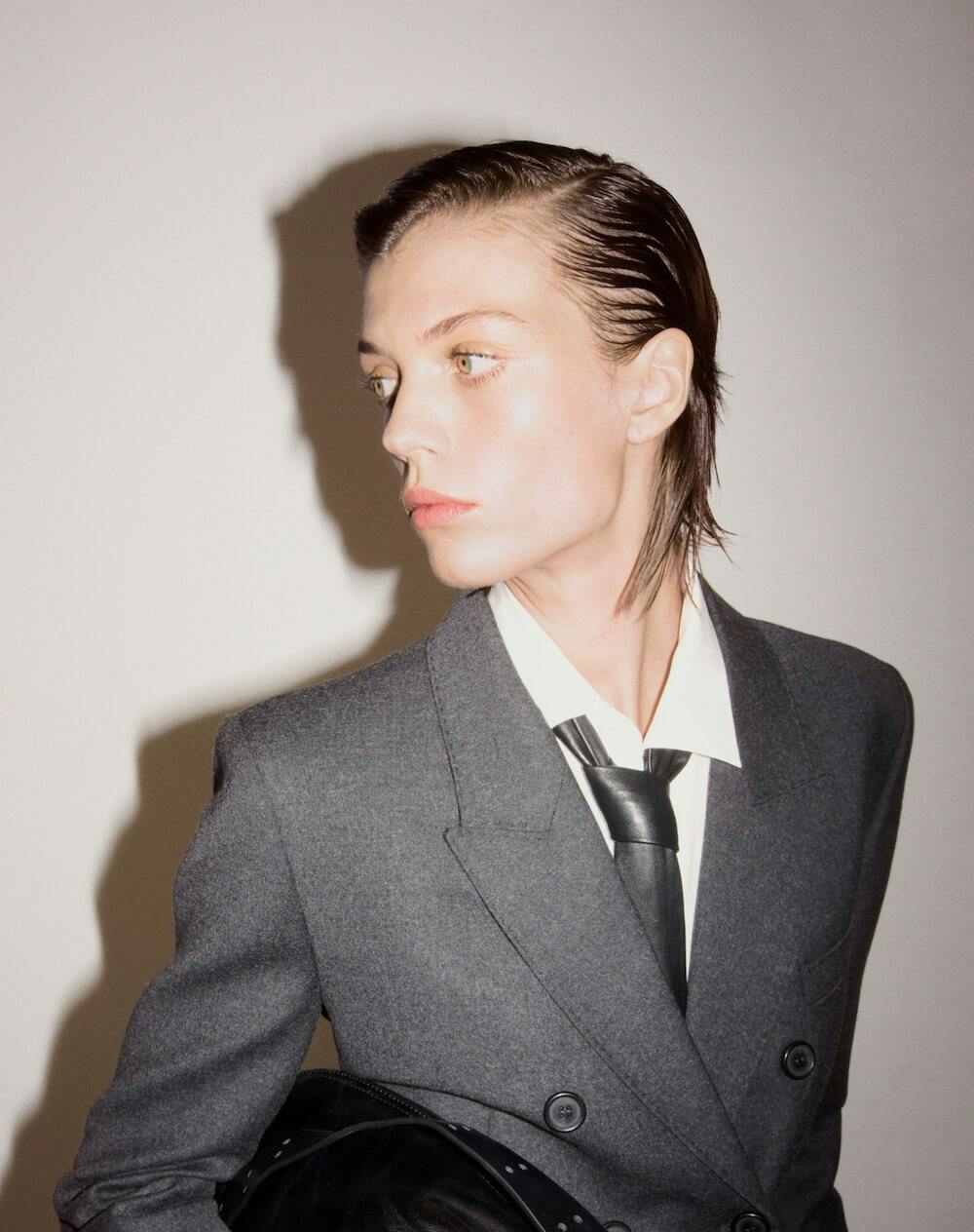 a woman in a dark suit is looking at the camera with her shoulder pressed a woman in a dark suit is looking at the camera with her shoulder pressed