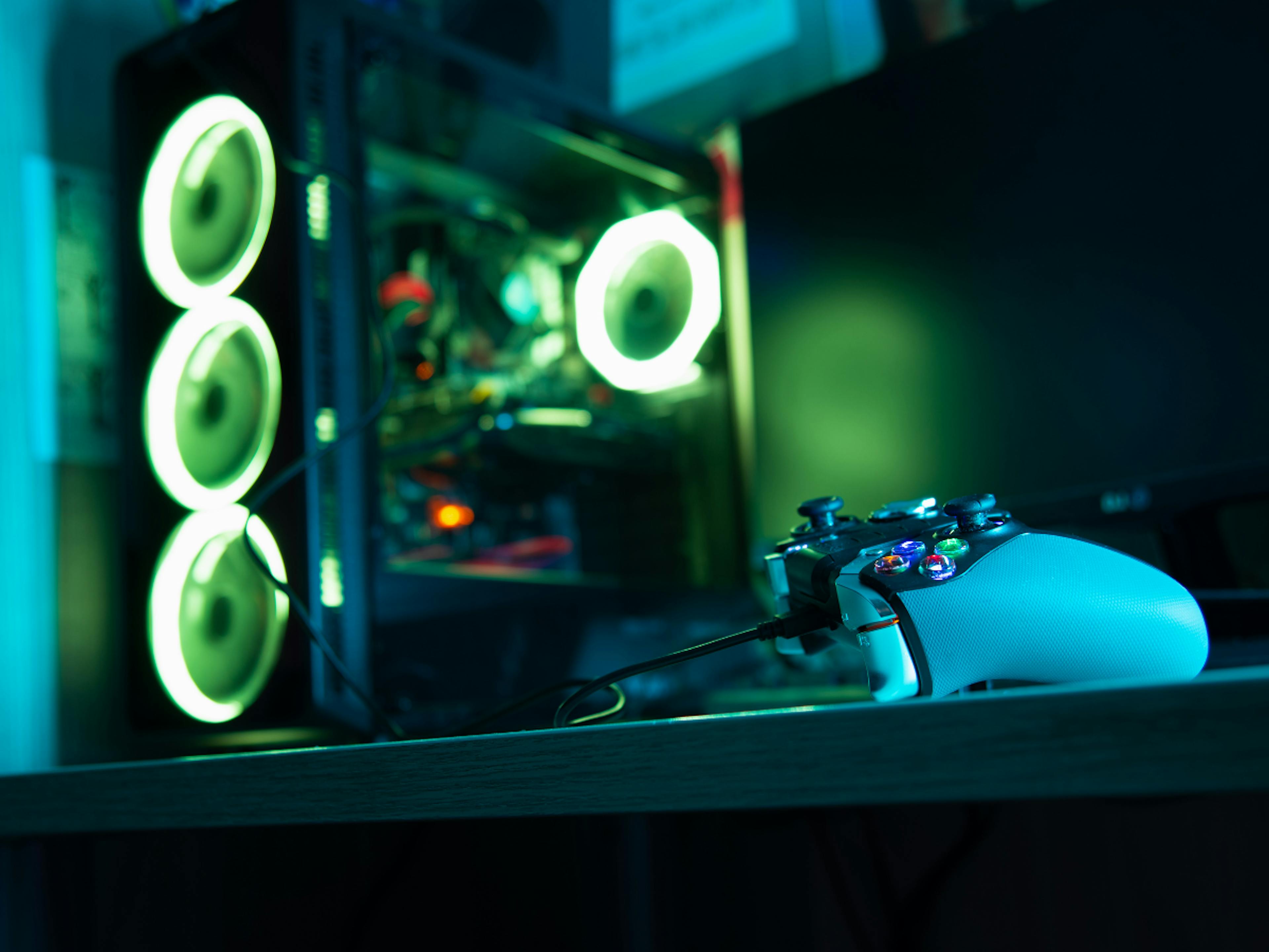 A controler on the front, and green light themed computer case on the background. 