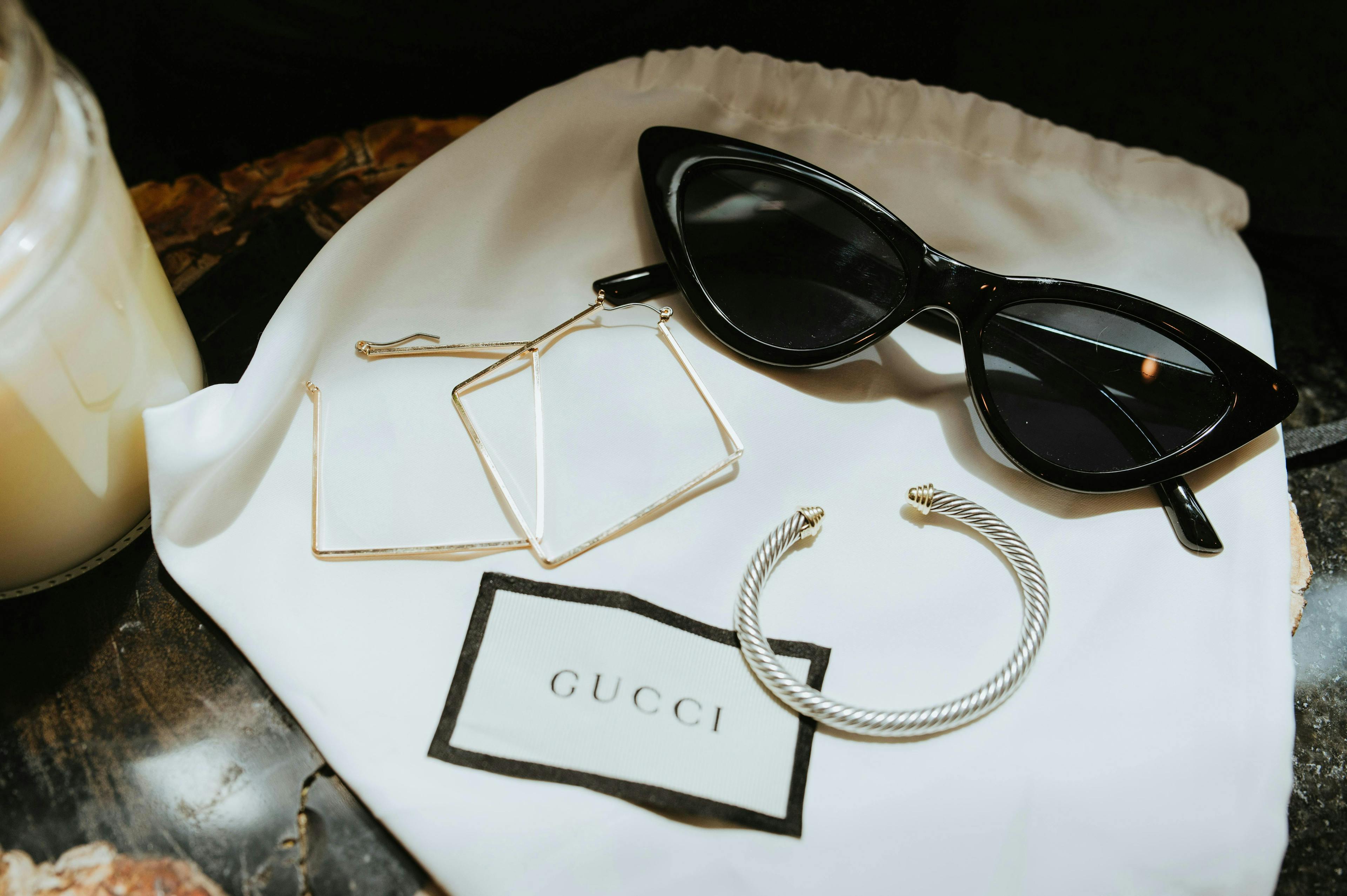 Gucci sunglasses and earrings with Gucci brand name. Gucci sunglasses and earrings with Gucci brand name.