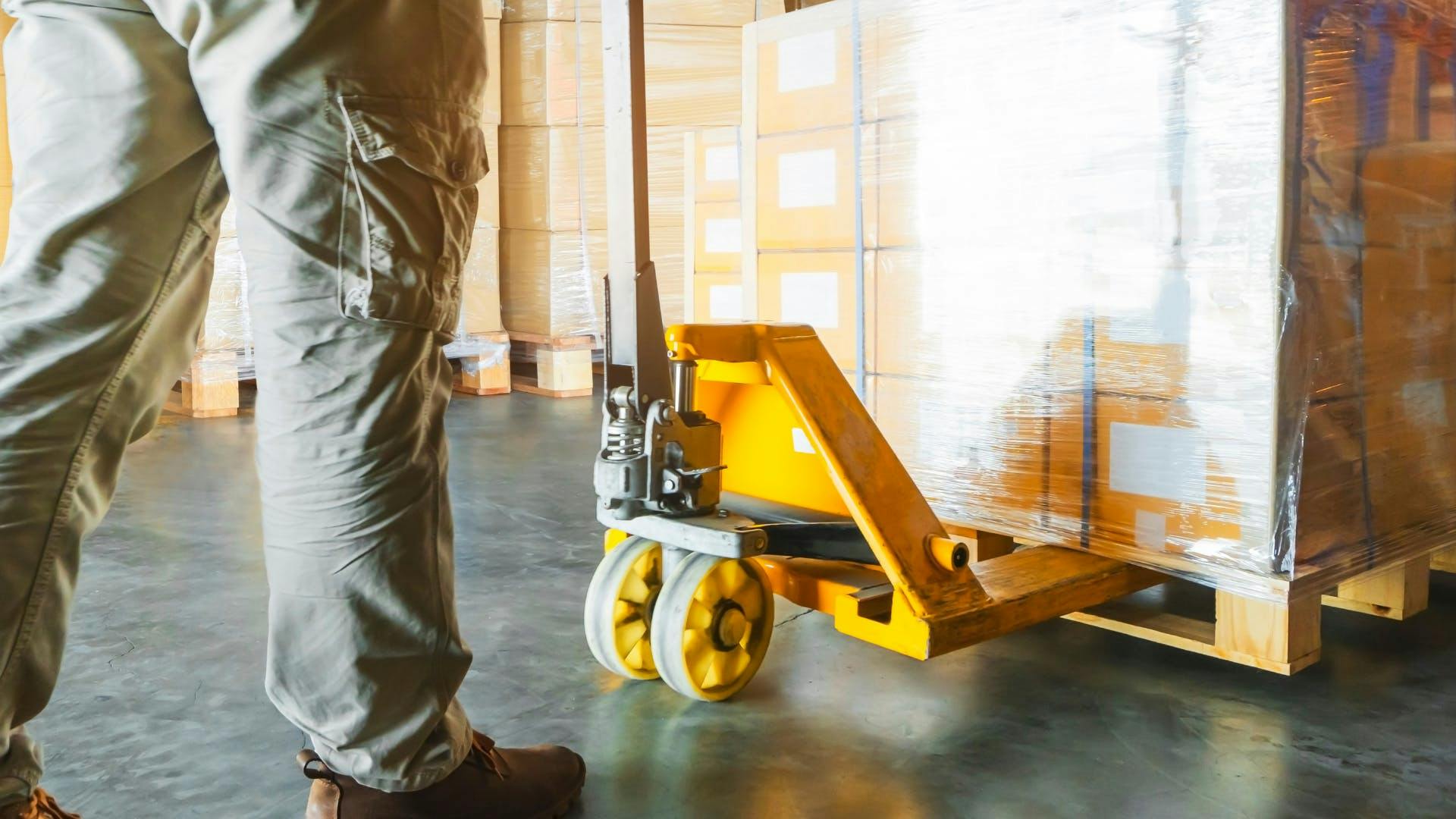 A man carrying a pallet to ship. 