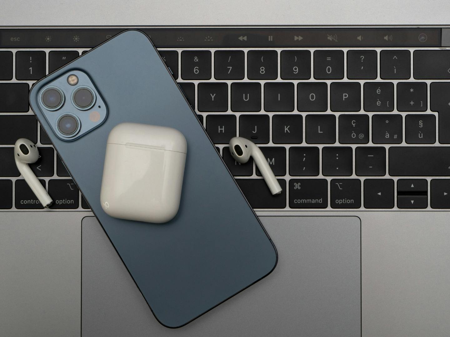 iPhone, AirPods and AirPod case on a Macbook. 