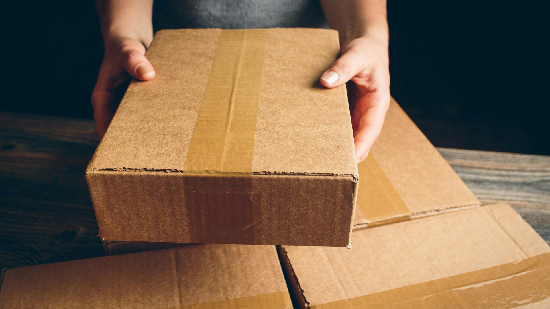 A close photo of a man holding a package.