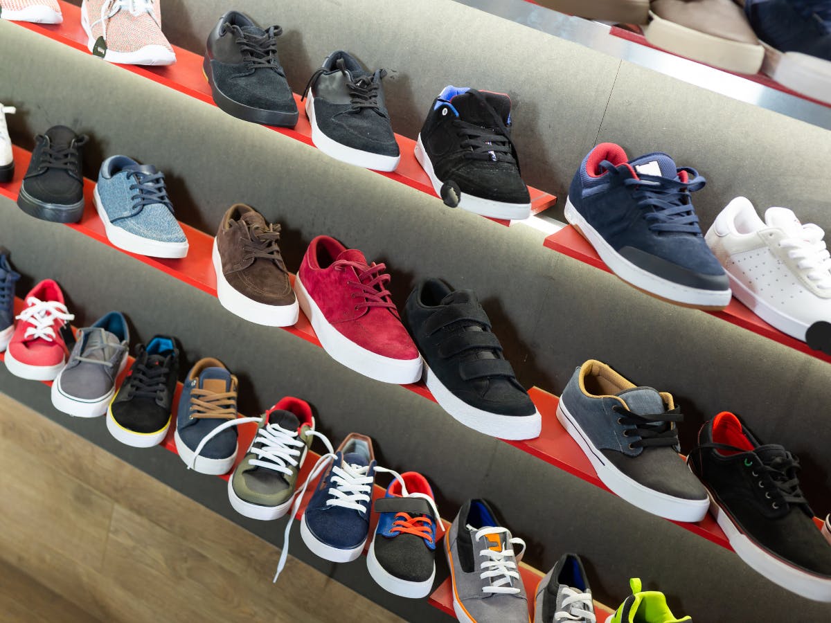 Different styles of sneakers on the shoe rack. 