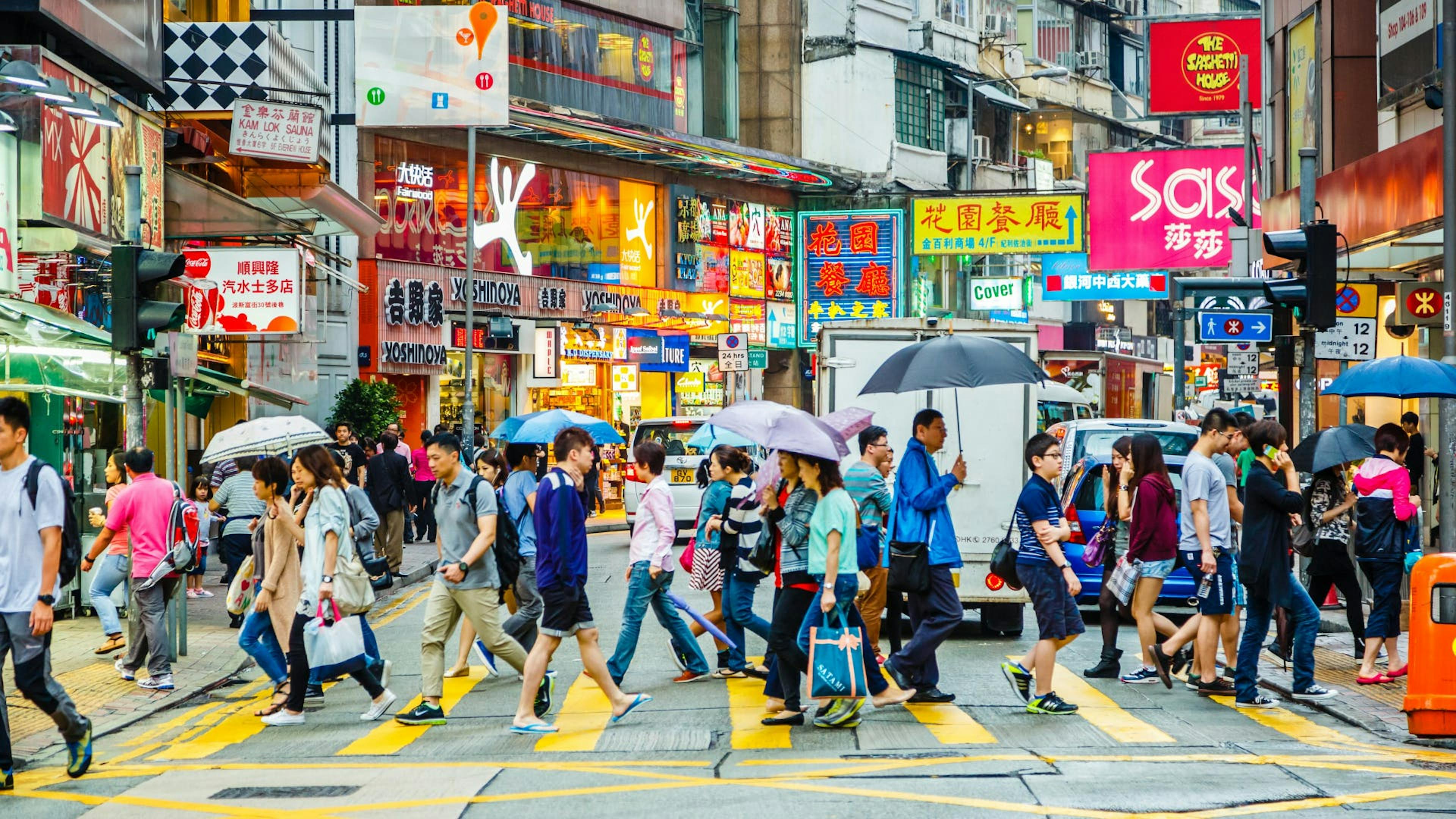 A crowded street while people crossing the road. 