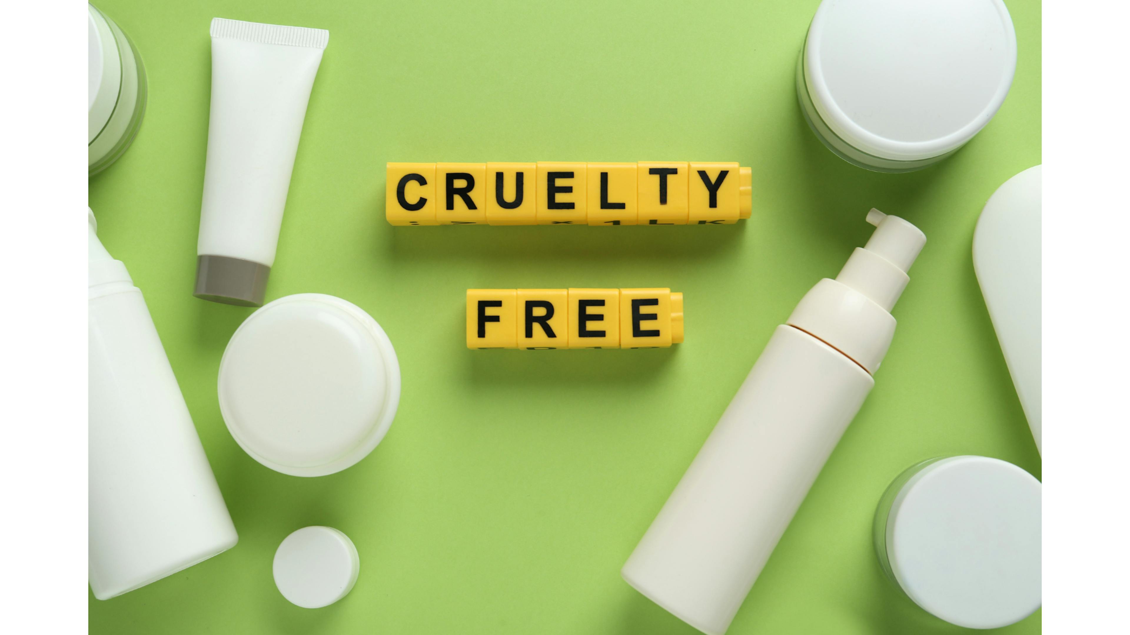 White make-up product bottles on a green background written "cruelty free" on it. 