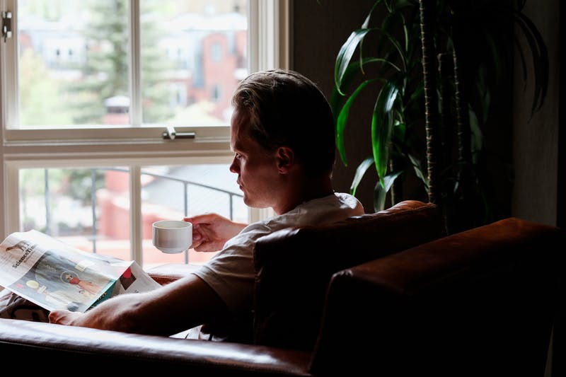 Tero, founder of Four Sigmatic drinking coffee and reading the newspaper
