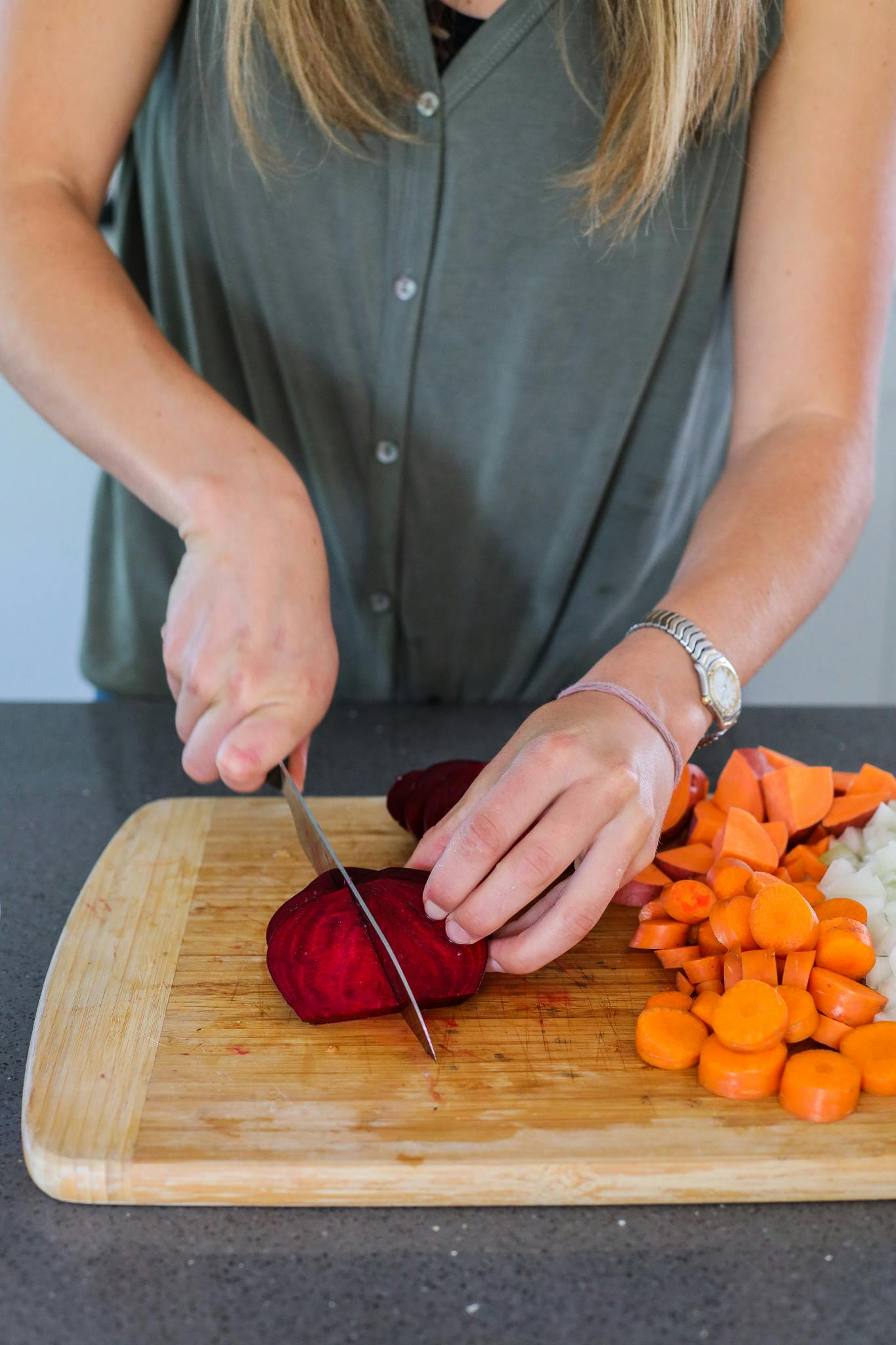 Woman cuts colorful, antioxidant rich veggies on a cutting board