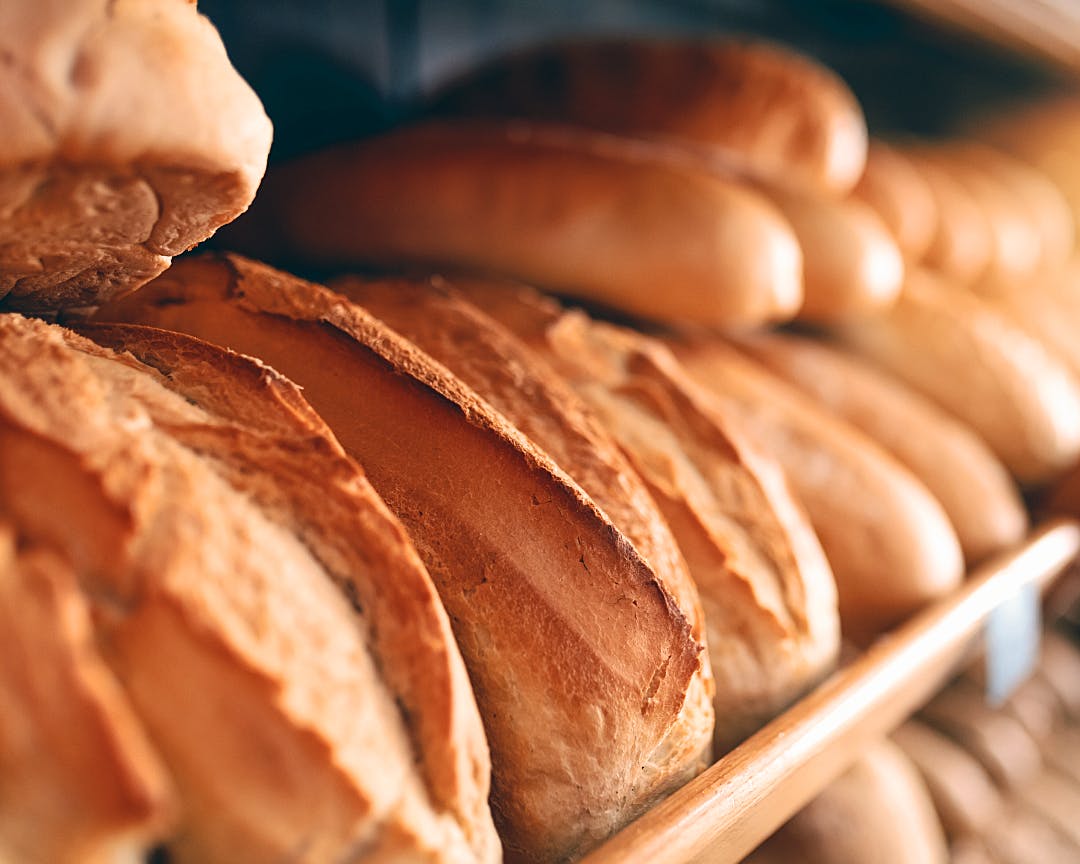 Loaves of baked bread displayed on a shelf with depth of field