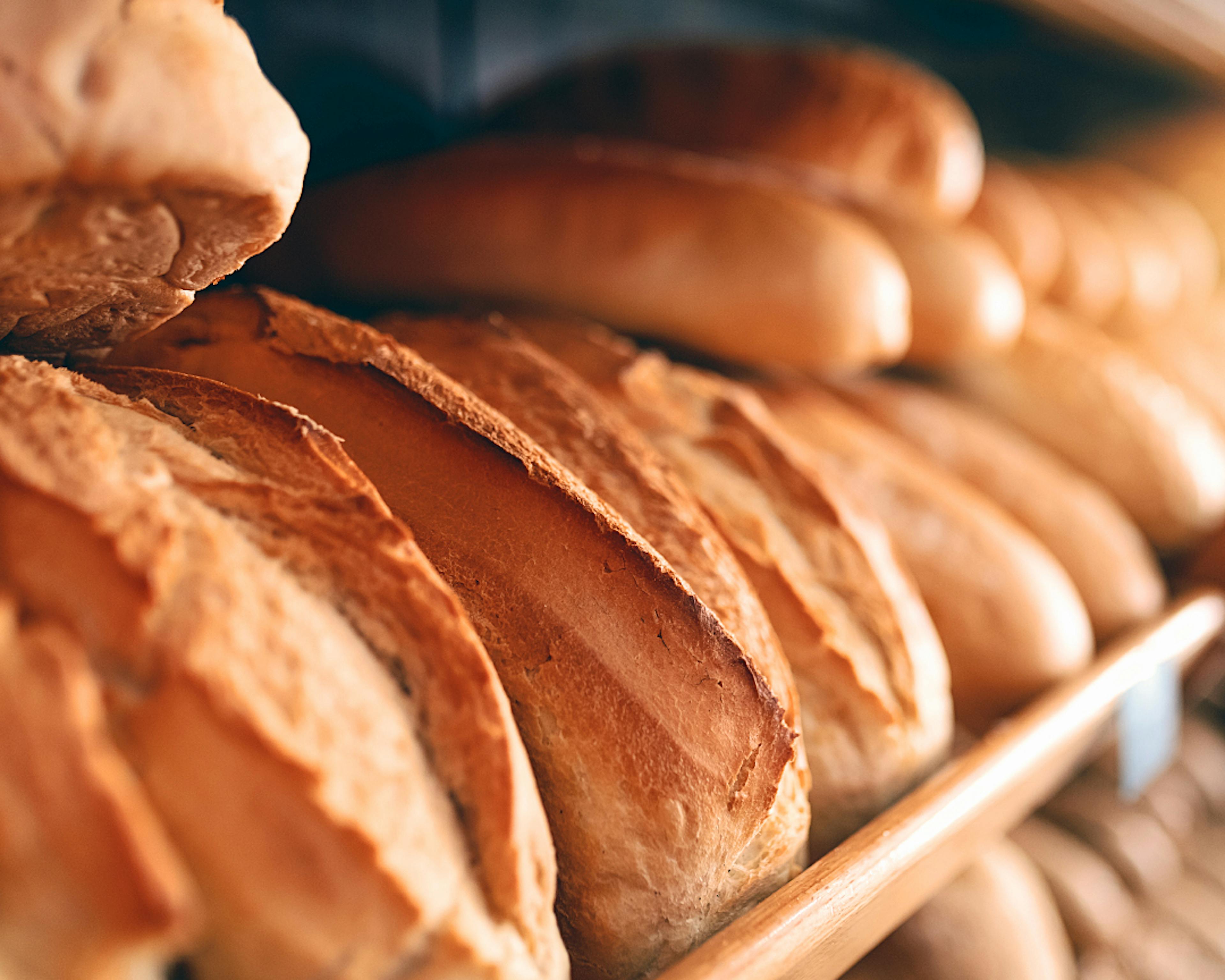Loaves of baked bread displayed on a shelf with depth of field