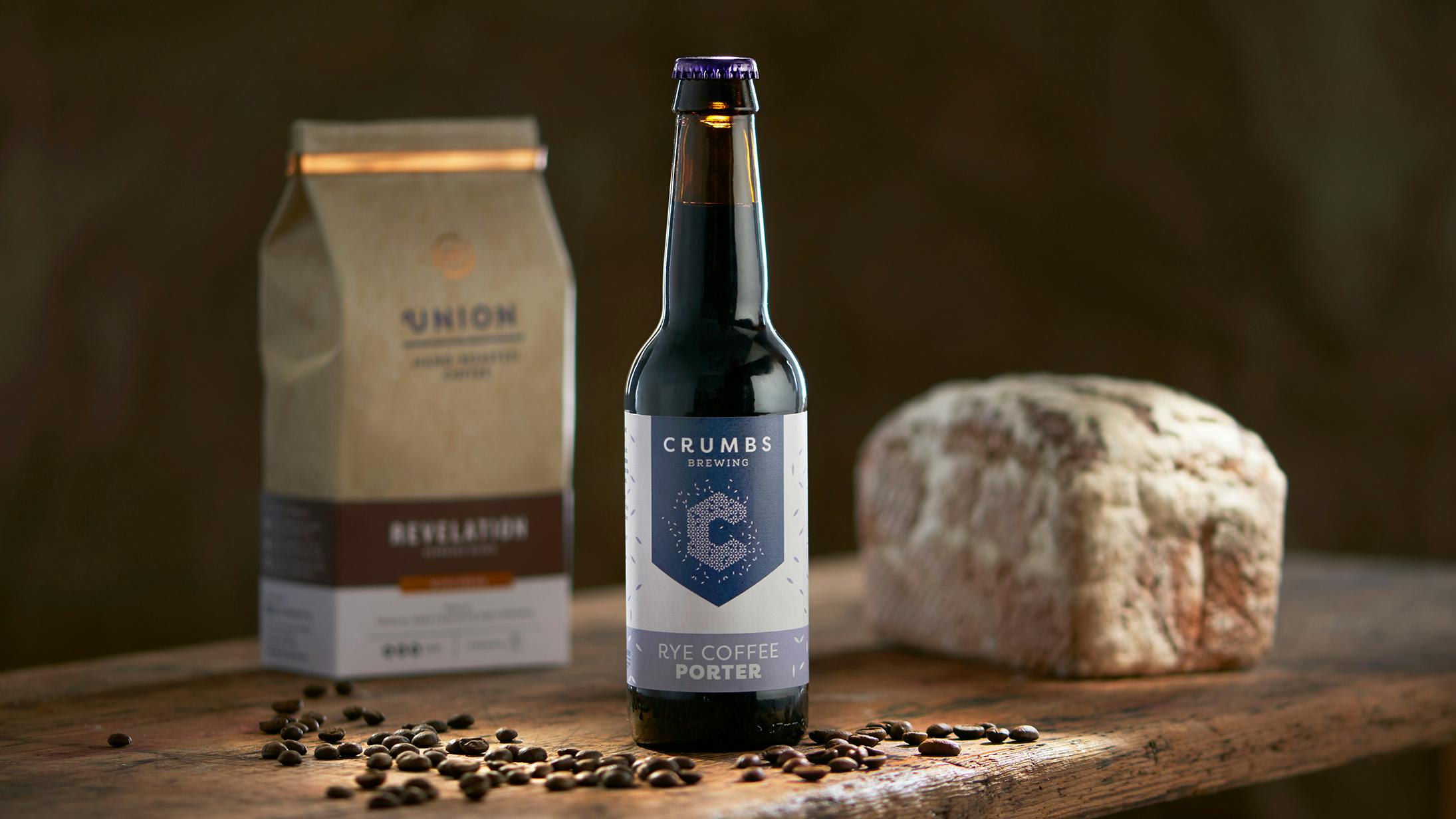 a Crumbs Rye Coffee Porter in-front of a loaf of bread and coffee bag