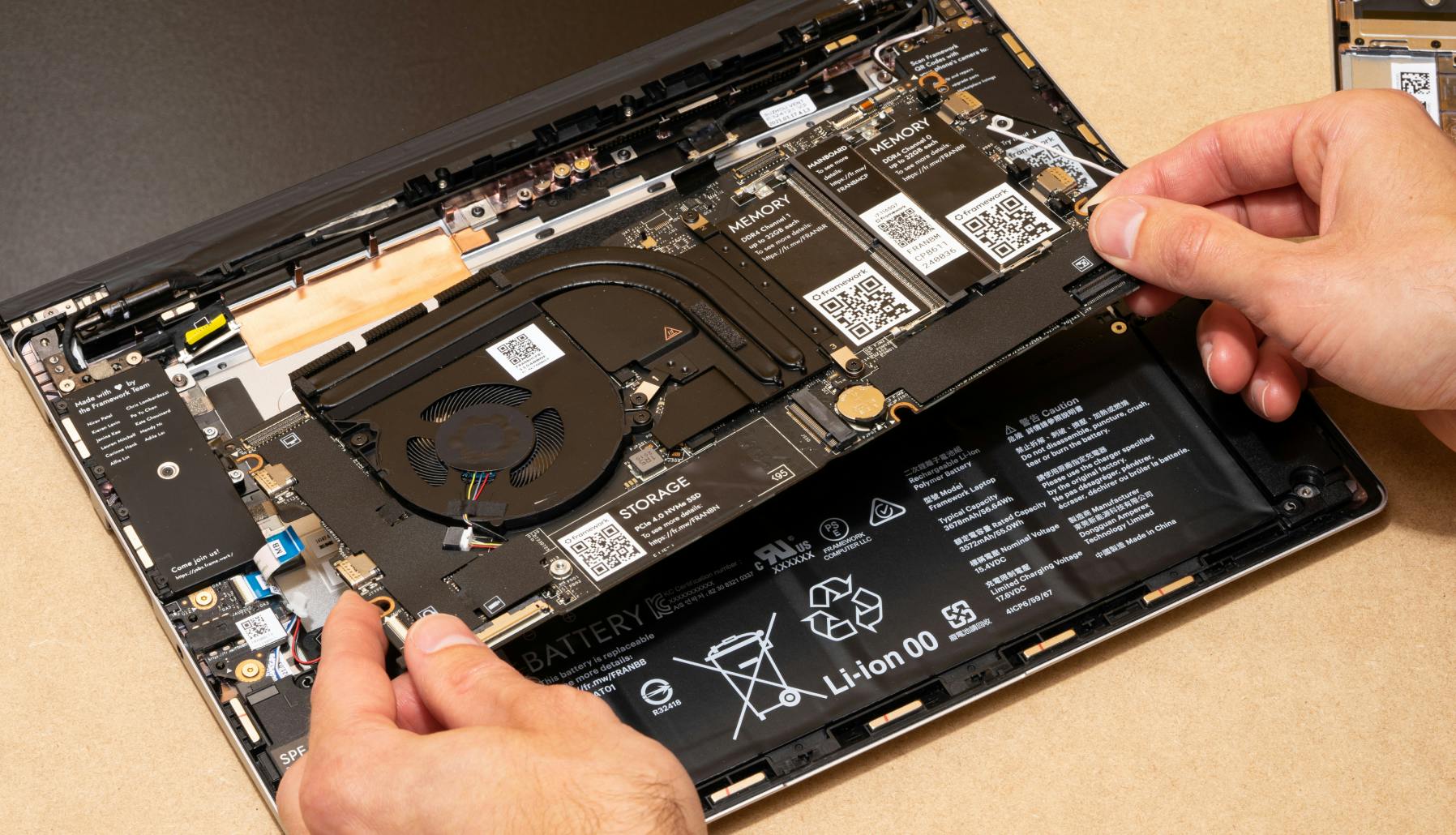 Someone removing the mainboard from the laptop.
