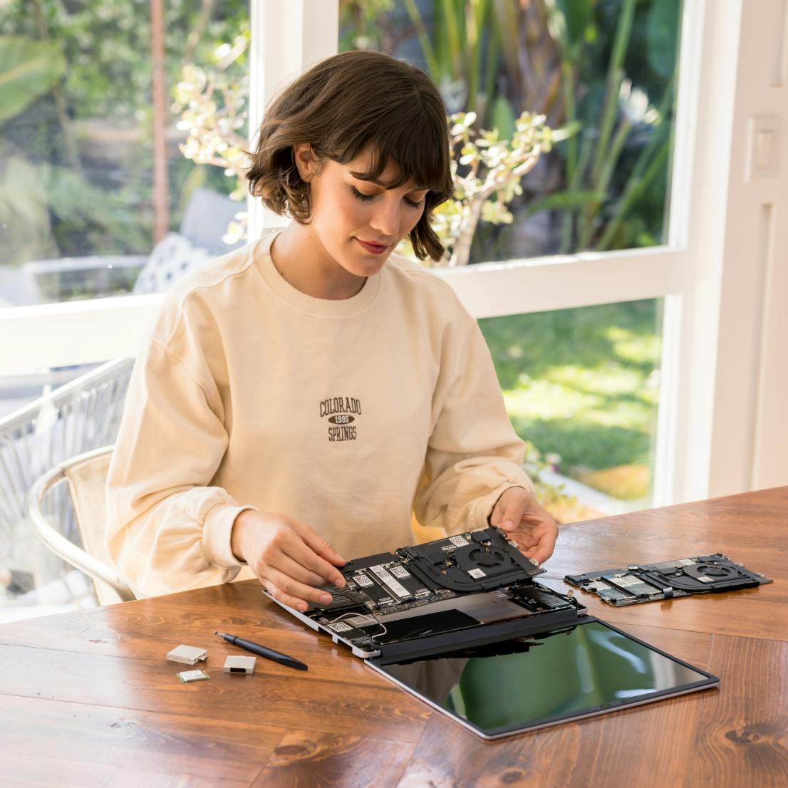A woman assembling a Framework Laptop on a table
