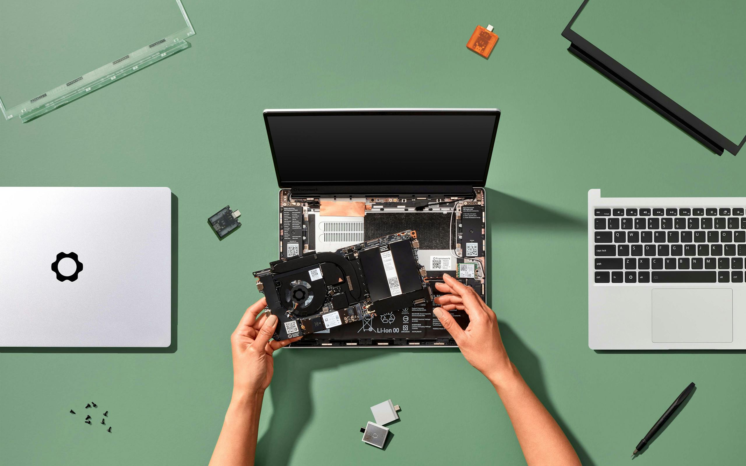 Hands placing a Framework Laptop 13 Mainbaord into a Framework Laptop 13